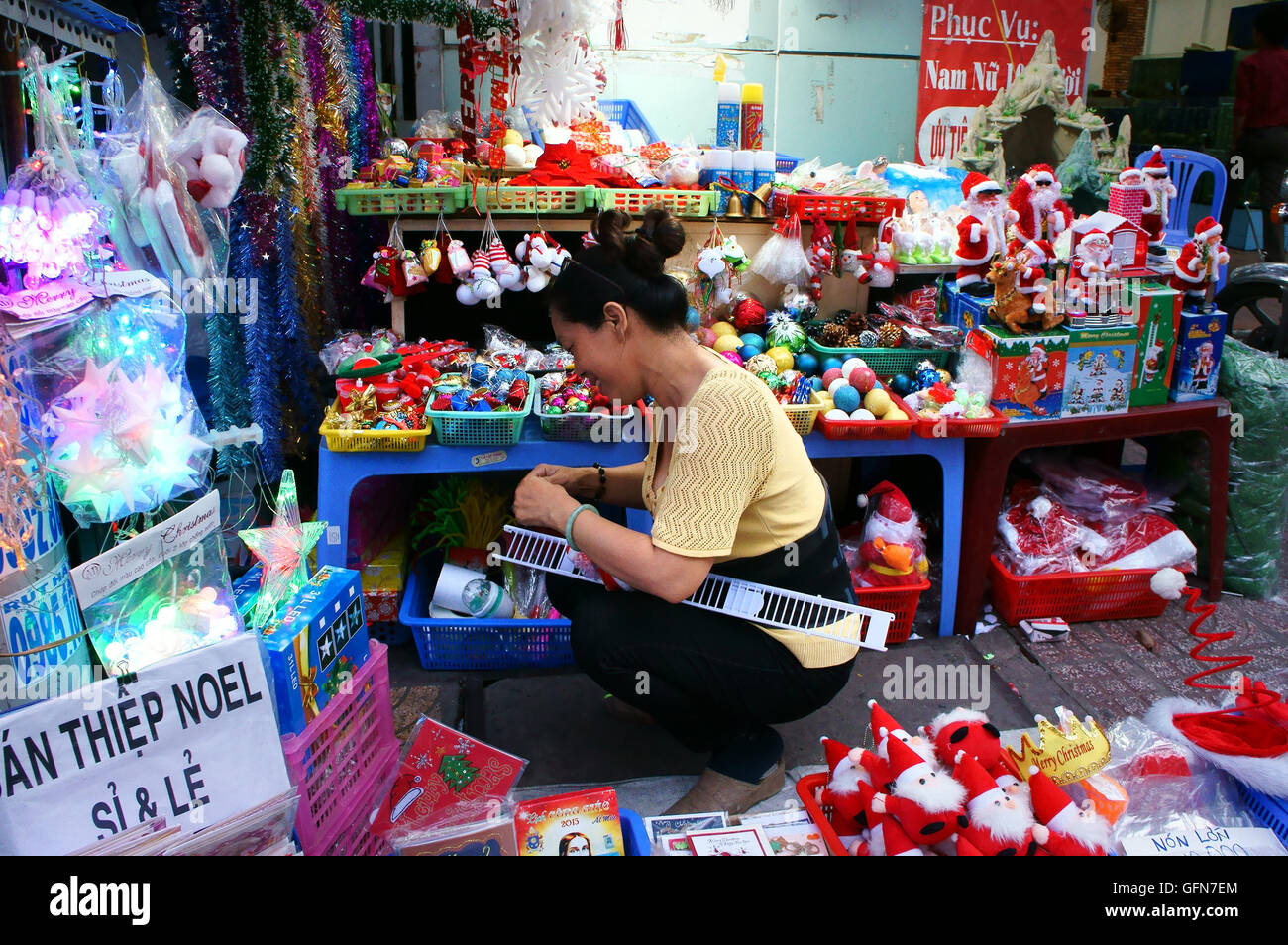 Vietnamesische Leute einkaufen bei Marktplatz Ornament für Weihnachten zu kaufen, bunte Dekoration für die Wintersaison zeigen bei Store, Saigon, Vietnam Stockfoto