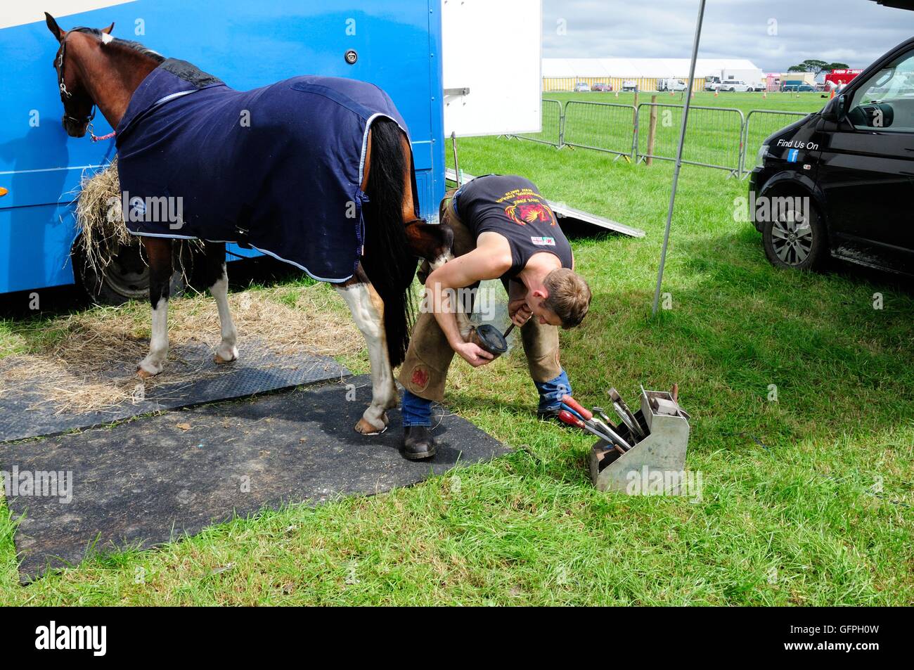 Fit junge Hufschmied beschlagen eines Pferdes auf eine landwirtschaftliche Show Stockfoto