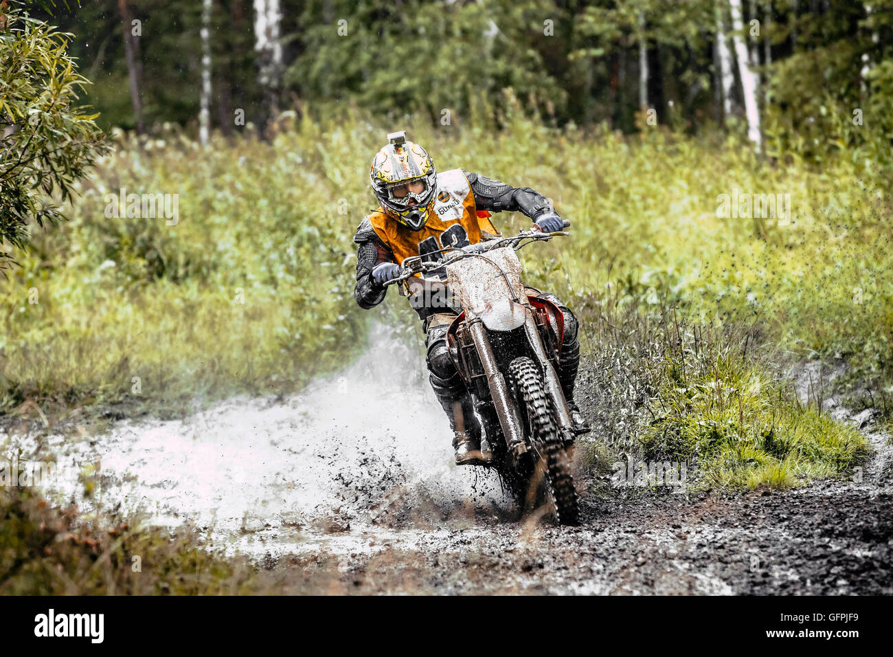 männliche Motorradfahrer fährt Rad durch eine Pfütze Schlamm im Wald während Ural Cup in Enduro Stockfoto