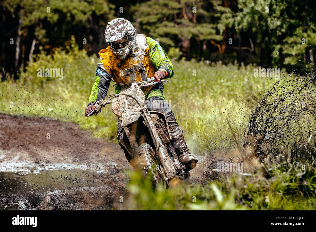 Athlet Motorradfahrer fährt Rad durch eine Pfütze Schlamm im Wald während Ural Cup in Enduro Stockfoto
