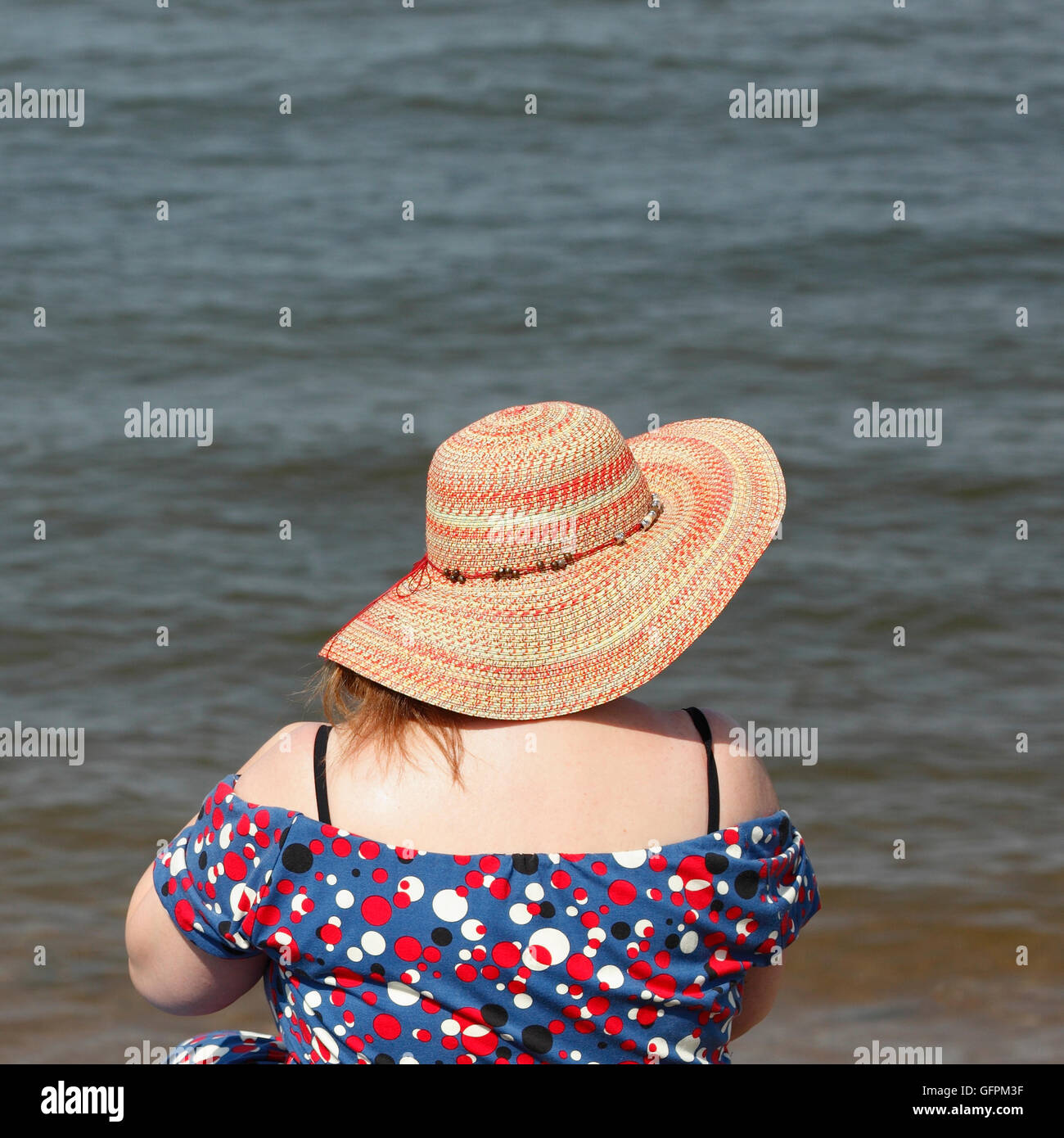 Frau trägt Stroh Sonnenhut am Strand an einem heißen Sommertag. Stockfoto