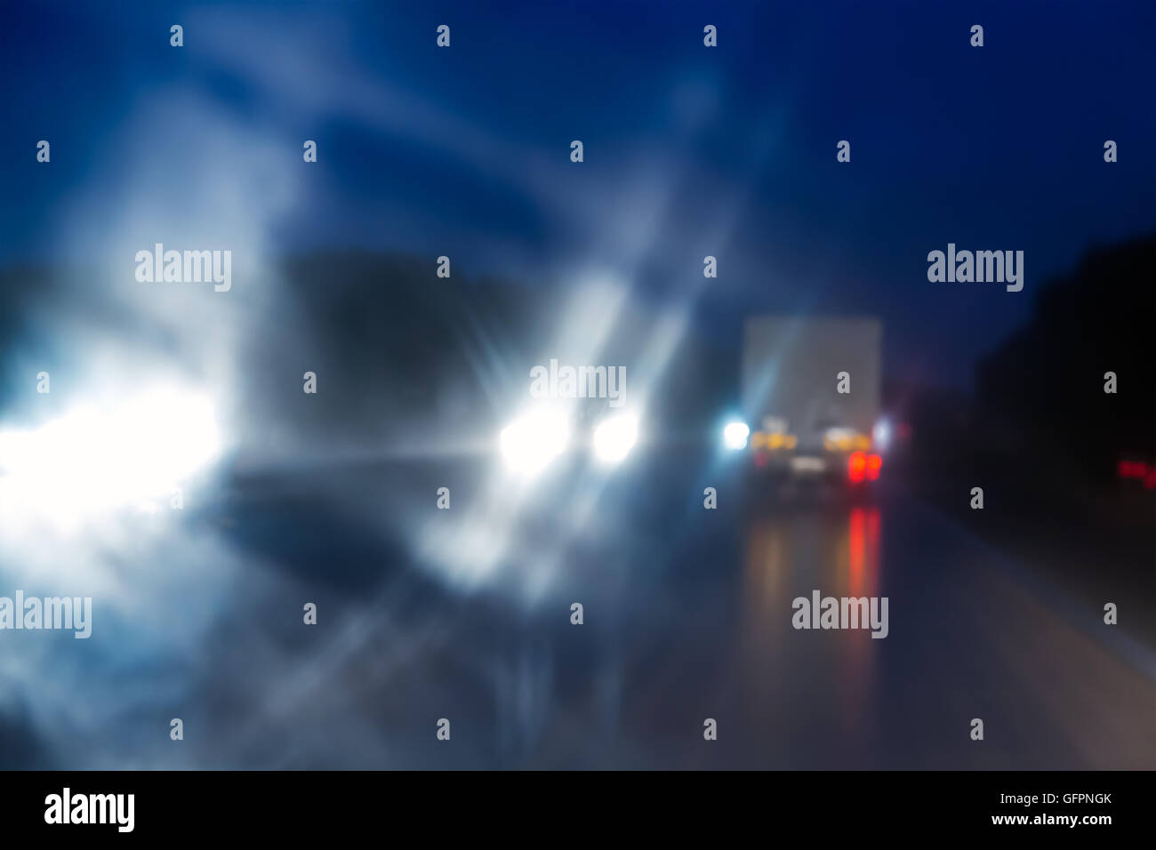 verschwommene Verkehr bei Nacht Road durch Windschutzscheibe Stockfoto