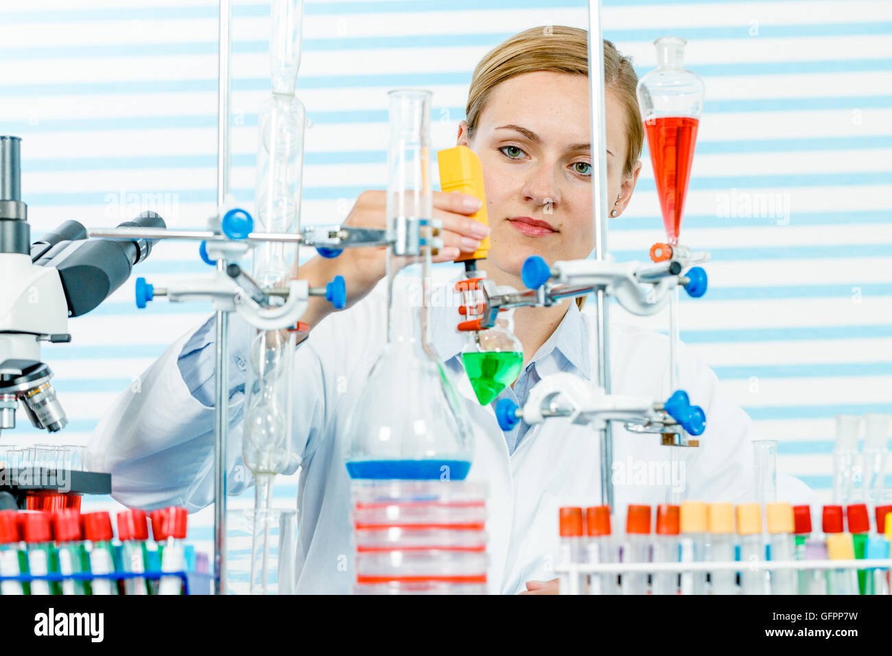 Chemisches Laboratorium Szene: attraktive junge Studentin Wissenschaftler beobachten die blaue Anzeige Farbverschiebung nach der Lösung Stockfoto