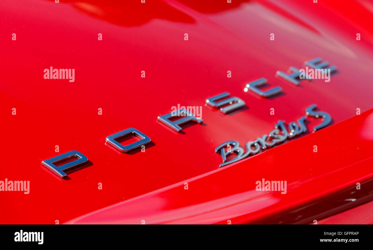 Nahaufnahme Schuss eines Porsche-Abzeichen auf ein rotes Auto Stockfoto
