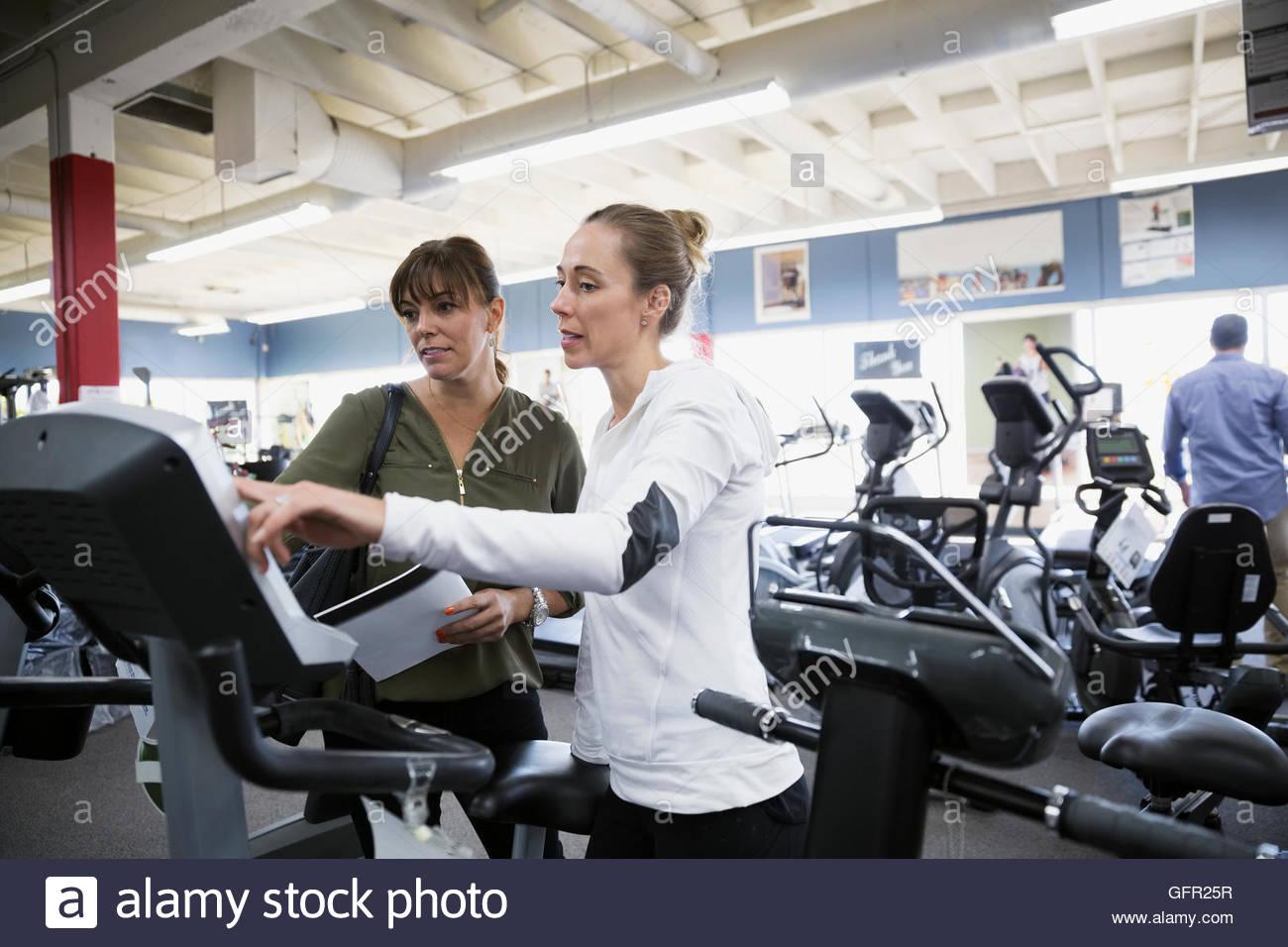 Verkäuferin hilft Frau Surfen Cardio Maschinen zu Hause Fitness-Studio Ausrüstung Shop Stockfoto