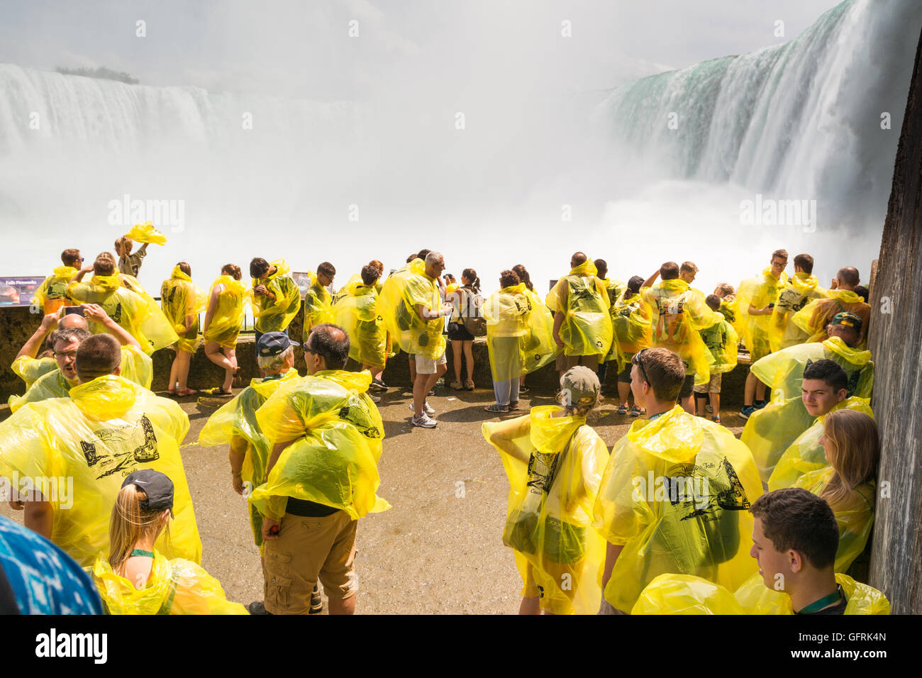 Niagara Falls, Kanada - Touristen auf der unteren Aussichtsplattform am Fuße des Wasserfalls tragen markante gelbe ponchos Stockfoto