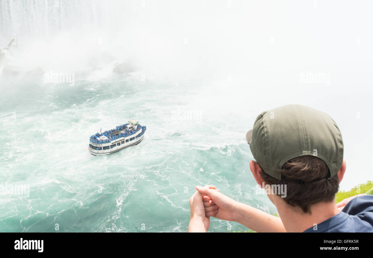 Niagara Falls, Ontario, Kanada - junge Mann an Mädchen des Nebels Boot voller Touristen nähern die Horseshoe Falls auf der Suche Stockfoto