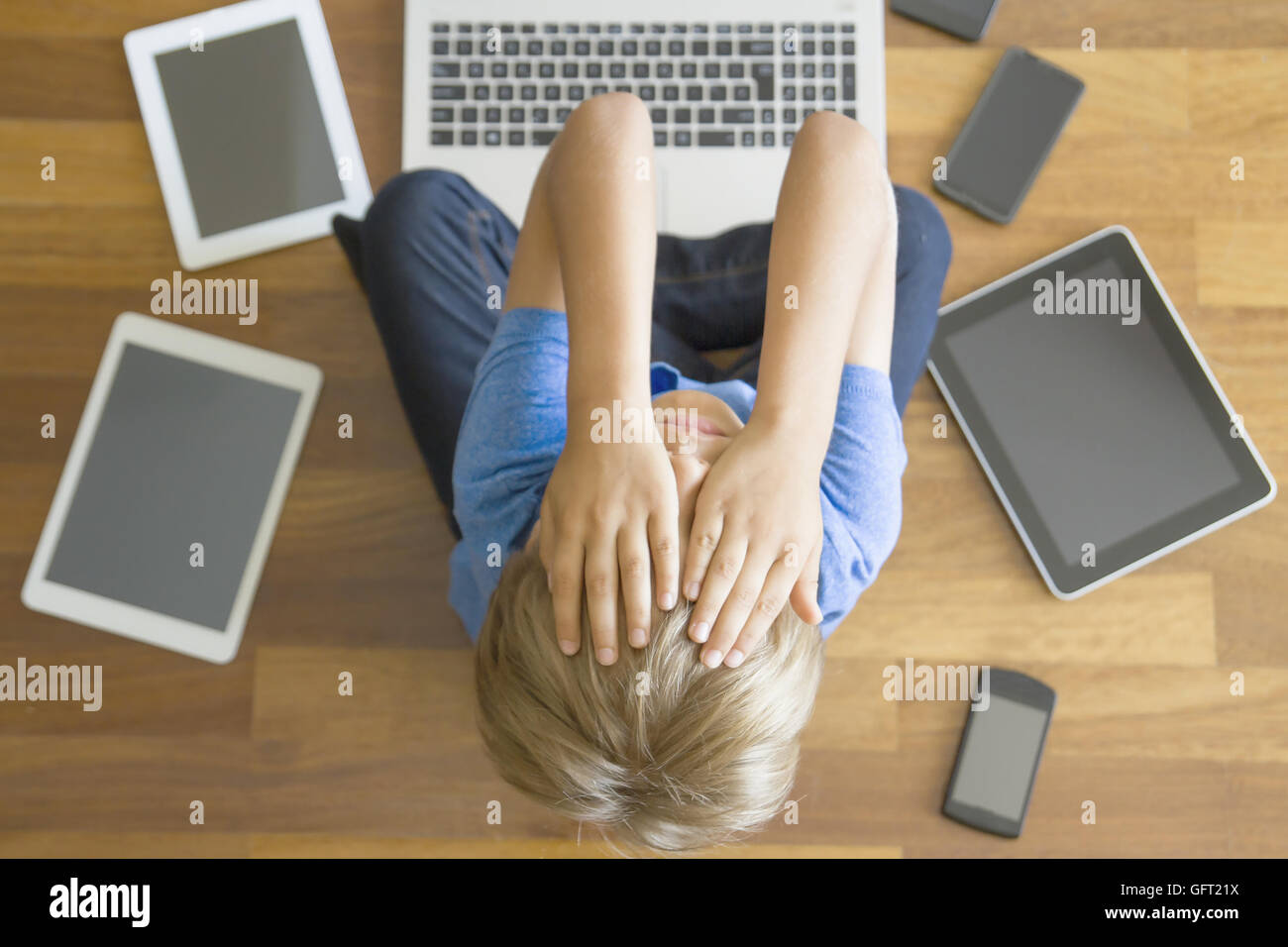 Müde, traurig junge mit Tabletten, Handys, Laptop überall zu Hause. Ansicht  von oben. Bildung, lernen, Technik, sucht Konzept Stockfotografie - Alamy
