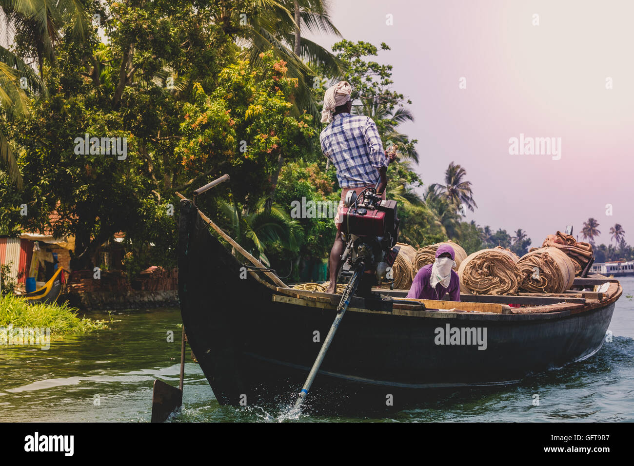 Allepey, Kerala, Indien 31. März 2015: Indischer Mann Verkehr wohnen mit Reis für Boote. Backwaters Kanu im Zustand. Cochin Stockfoto