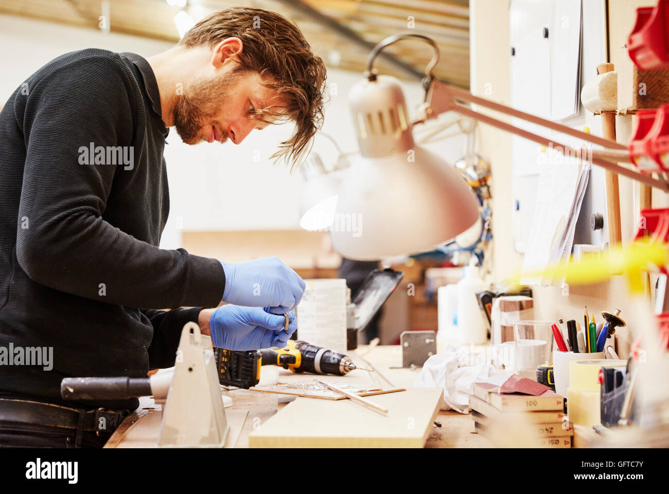 Ein Möbel Workshop A Mann stehend an einer Werkbank Stockfoto