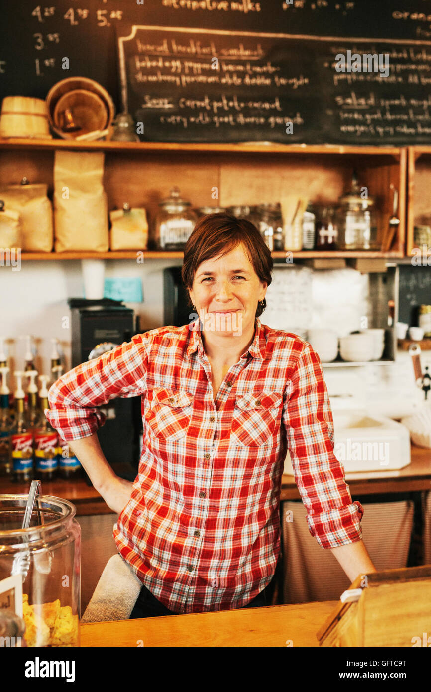 Eine Frau in einem Café hinter der Theke lächelnd Eigentümer Stockfoto