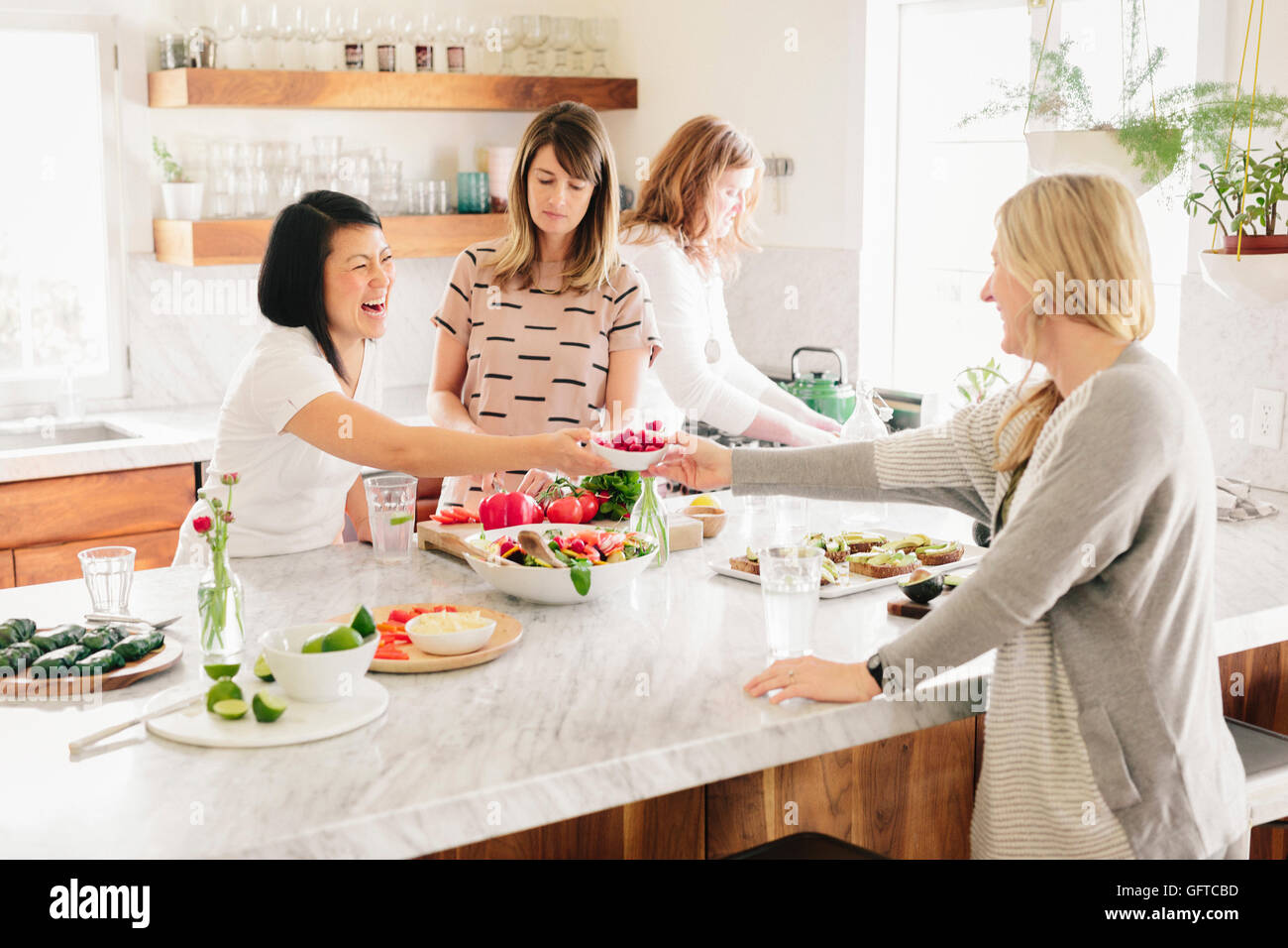 Vier Frauen in einer Küche Mittagessen vorbereiten Stockfoto