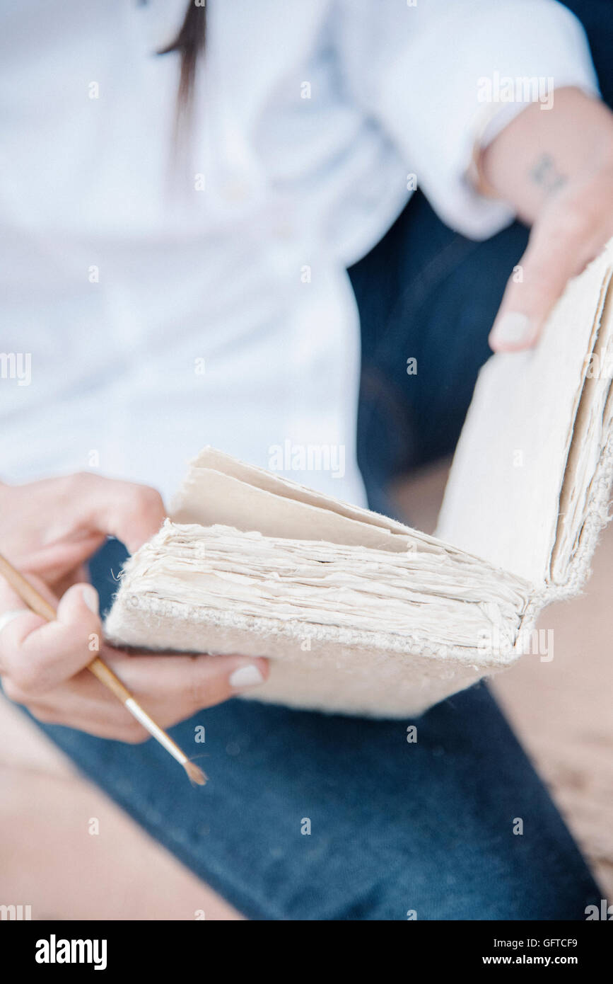 Nahaufnahme einer Frau mit einer Skizze-Buch und Farbe Bürste Stockfoto