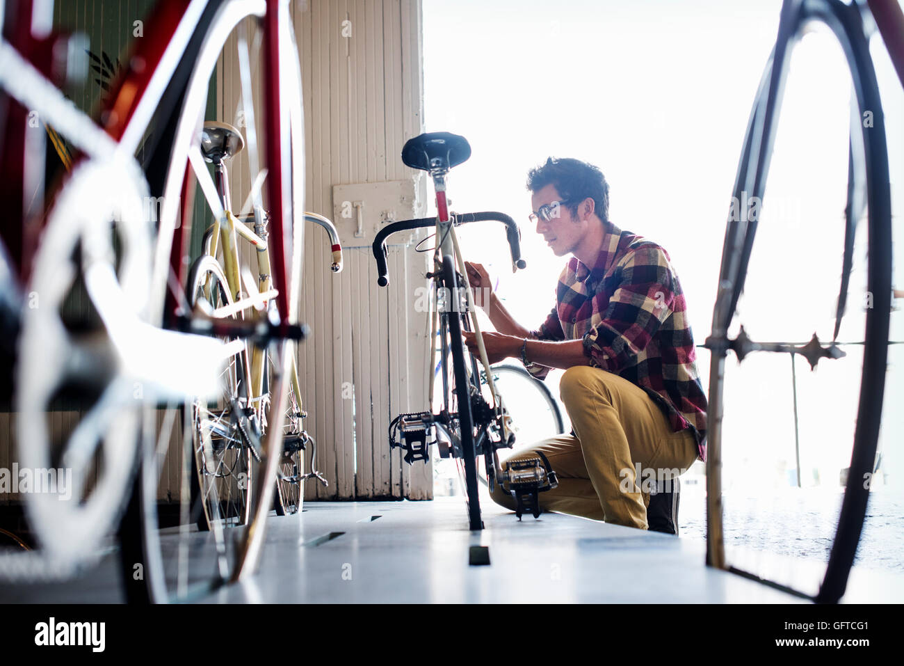 Ein Mann, der arbeitet in einer Fahrradwerkstatt Stockfoto