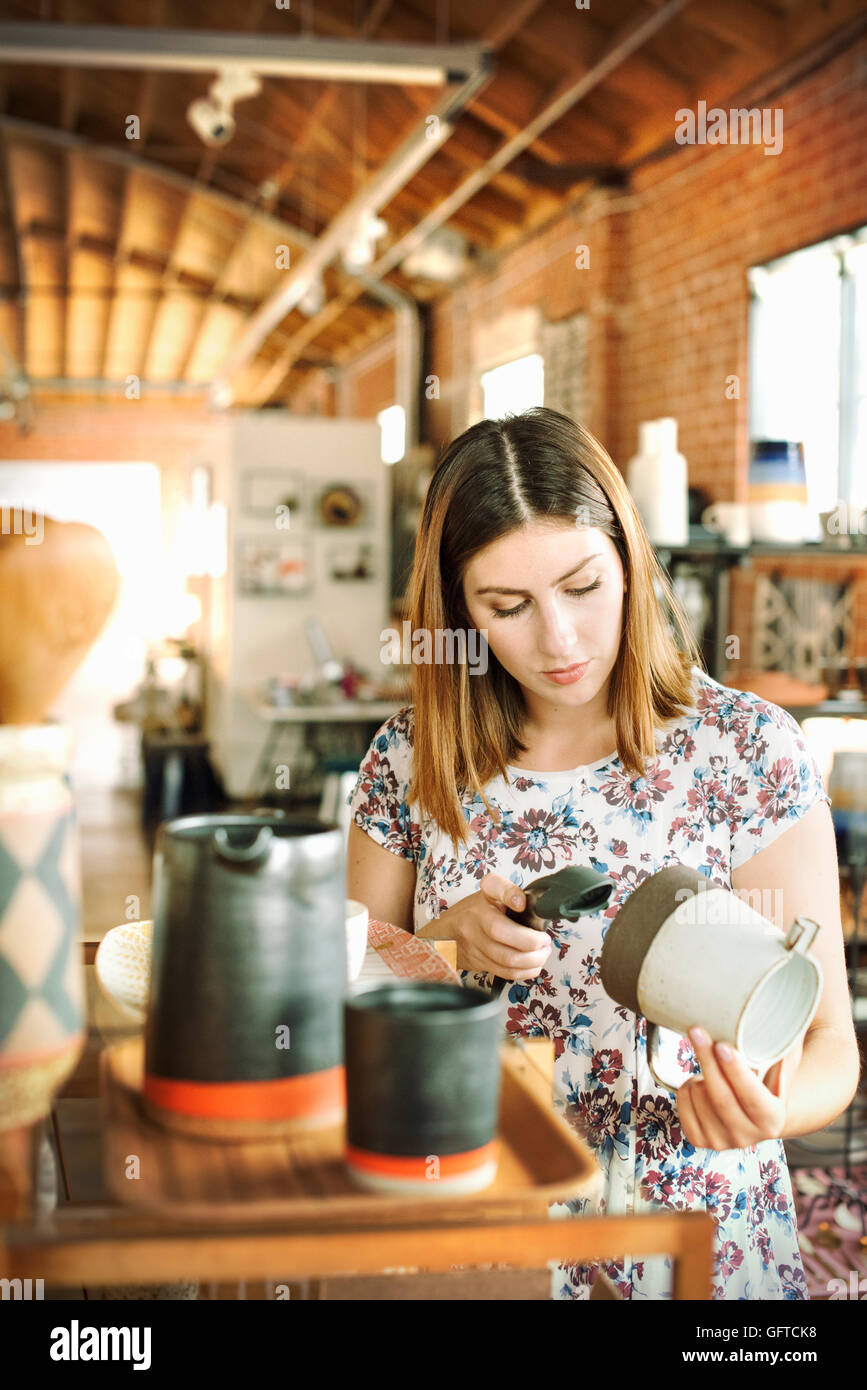 Junge Frau in einem Geschäft, Scannen den Barcode von einem Keramik Krug mit einem Barcodescanner Stockfoto