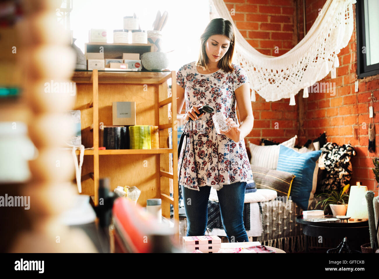 Junge Frau in einem Geschäft, Scannen den Barcode ein Trinkglas mit einem Barcodescanner Stockfoto