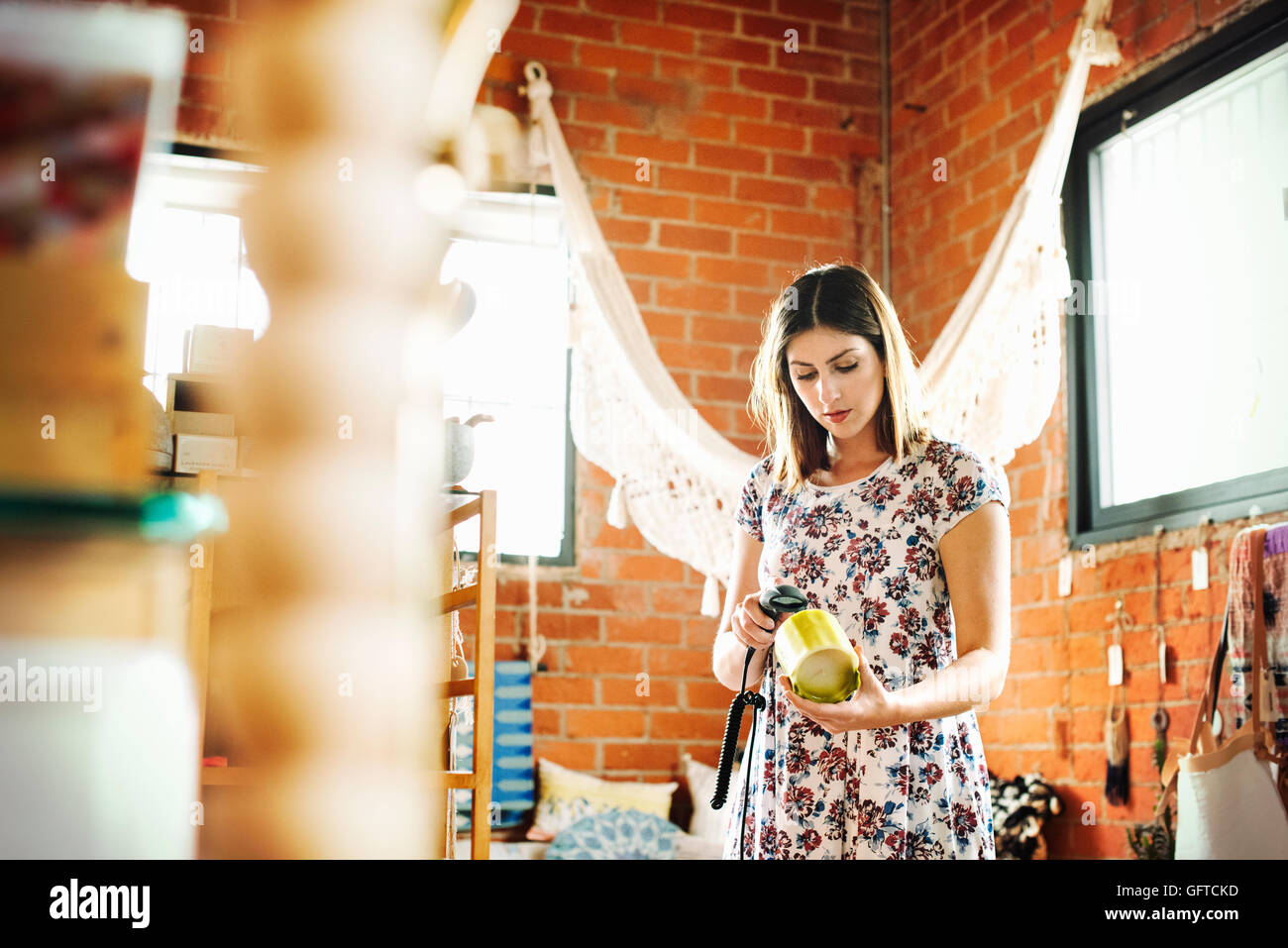 Junge Frau in einem Geschäft, Scannen den Barcode des eine Kerze mit einem Barcodescanner Stockfoto