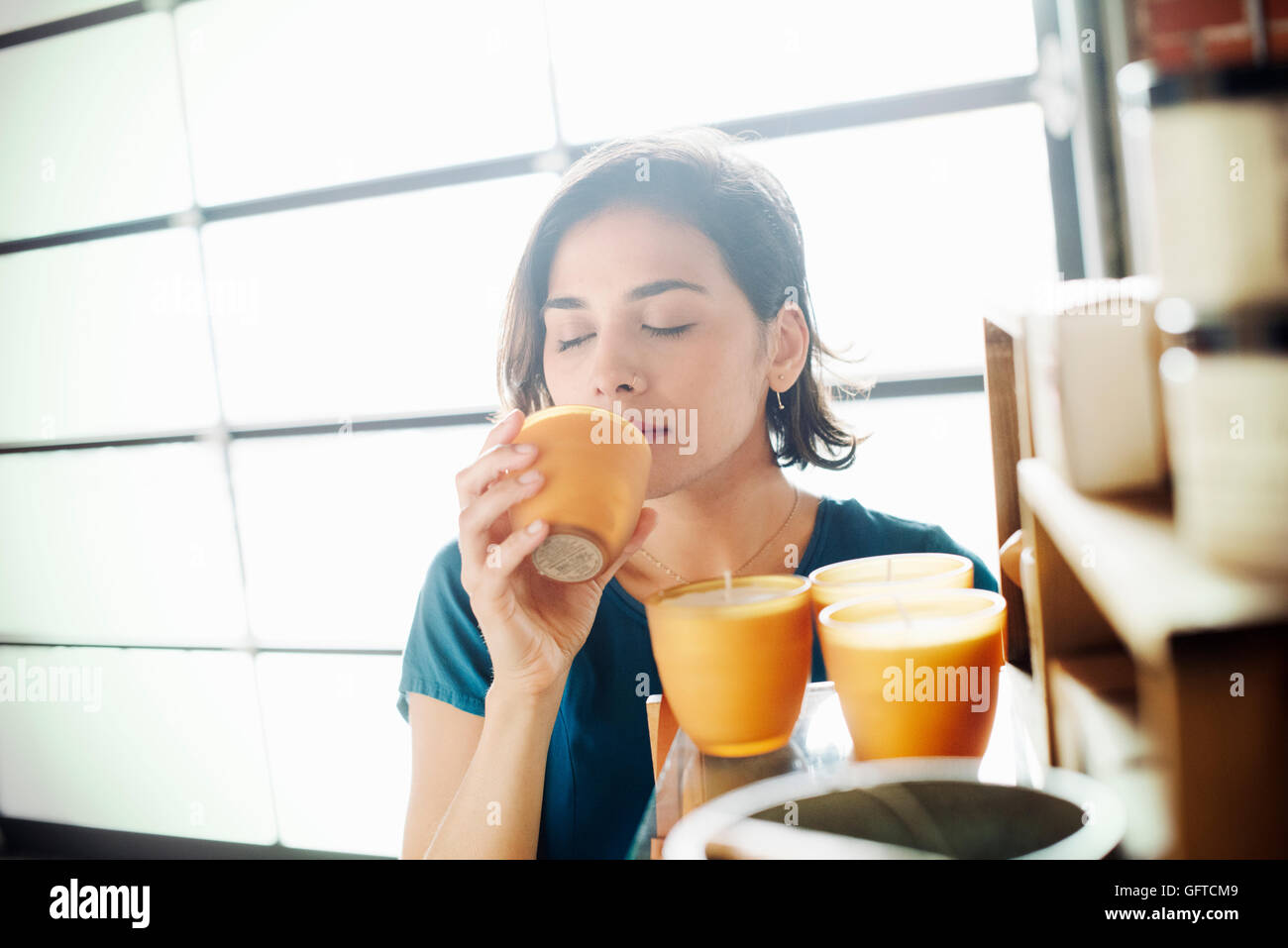 Junge Frau in einem Geschäft eine Duftkerze riechen Stockfoto