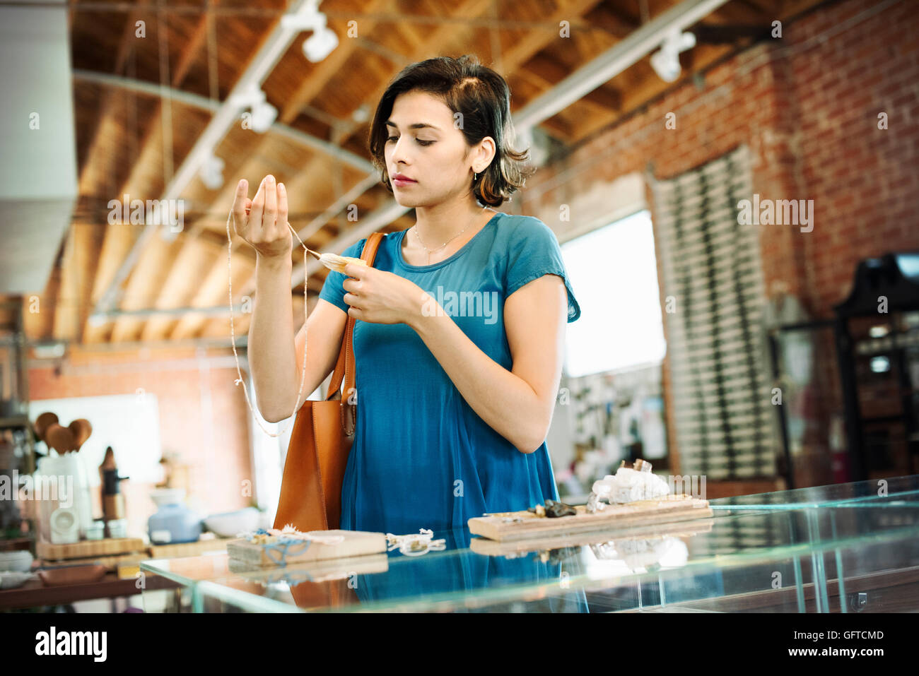 Junge Frau in einem Geschäft eine Halskette zu betrachten Stockfoto