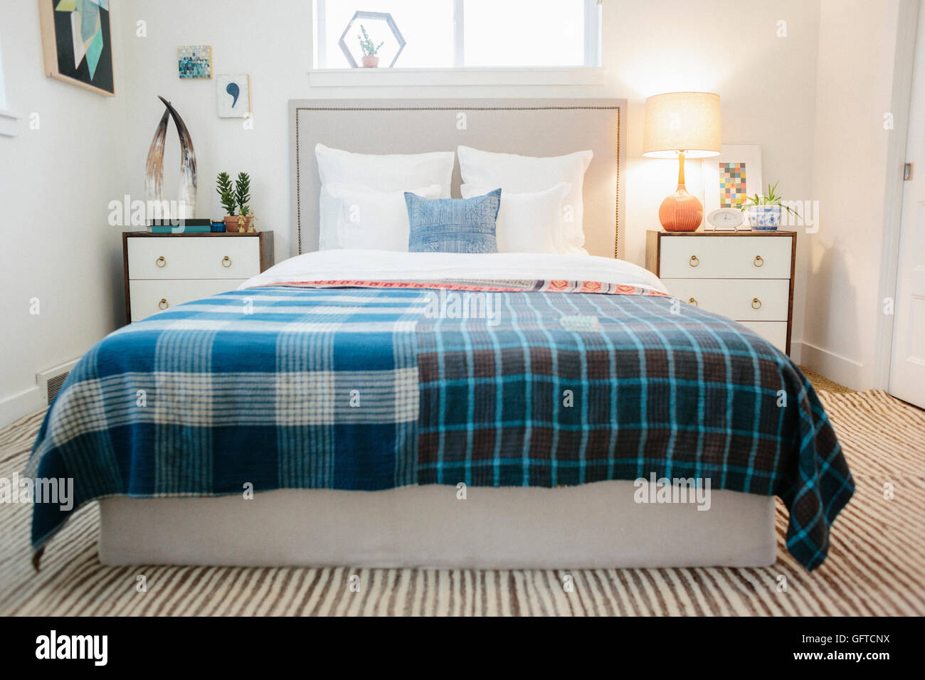 Ein Schlafzimmer in einem Apartment mit einem Doppelbett mit einer bunten aufgegebenes Bettdecke Stockfoto