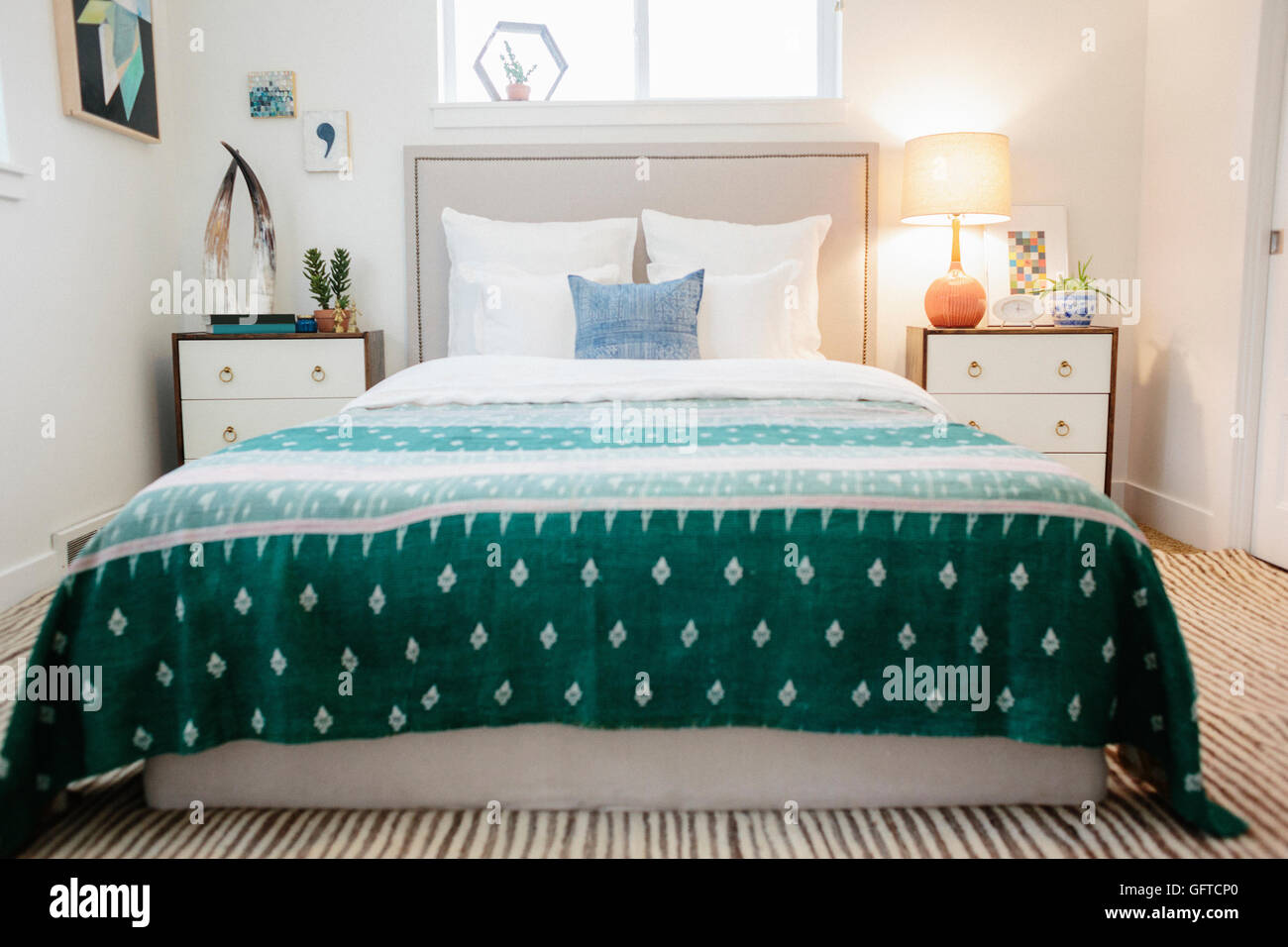 Ein Schlafzimmer in einem Apartment mit einem Doppelbett und einem jade grün gemustert Bettdecke Stockfoto