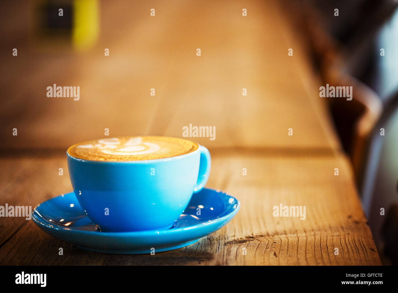 Eine blaue China Tasse und Untertasse mit schaumigen Kaffee Stockfoto