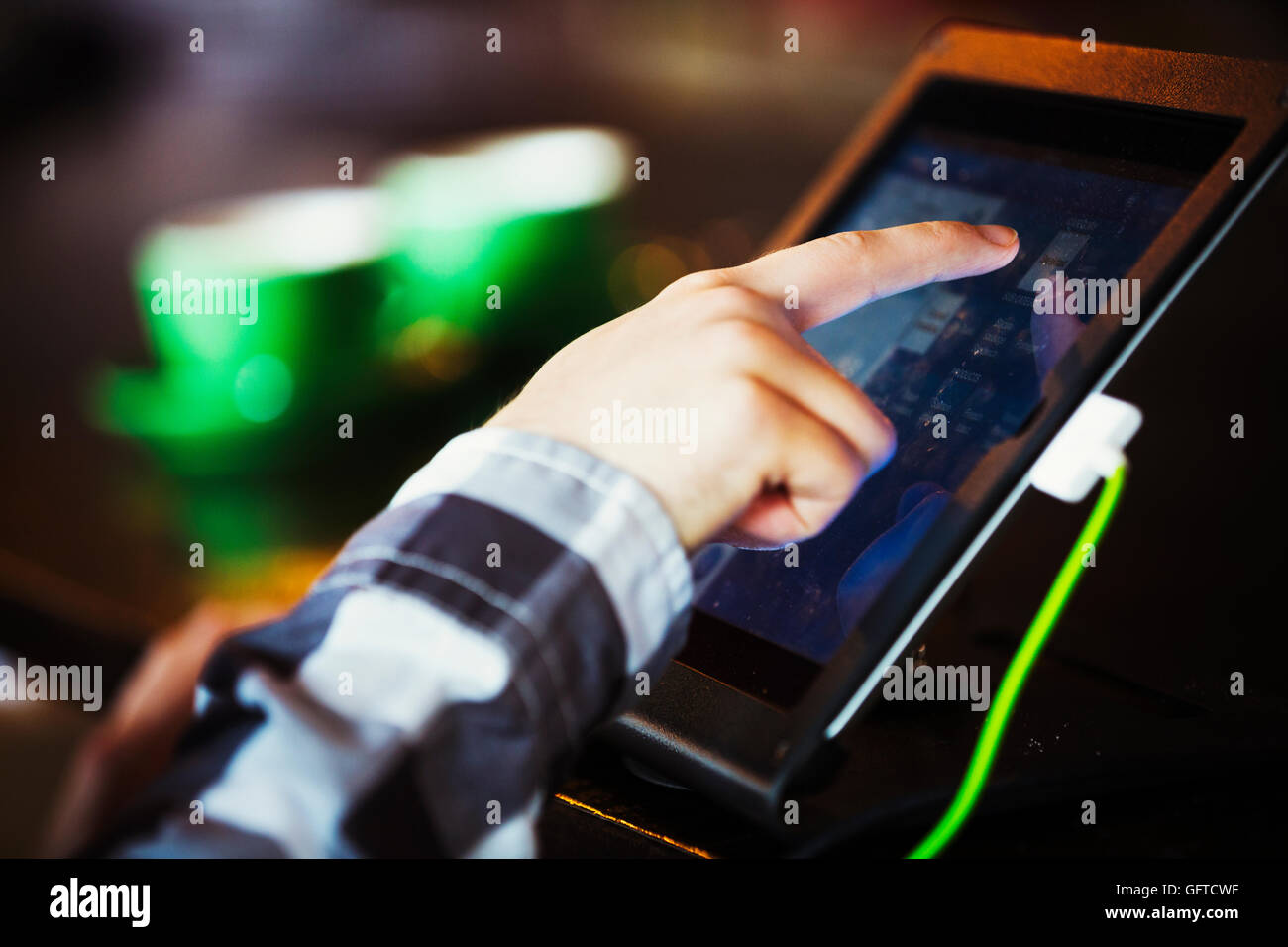 Eine Person mit einem Touch-Screen an einer Kasse Stockfoto
