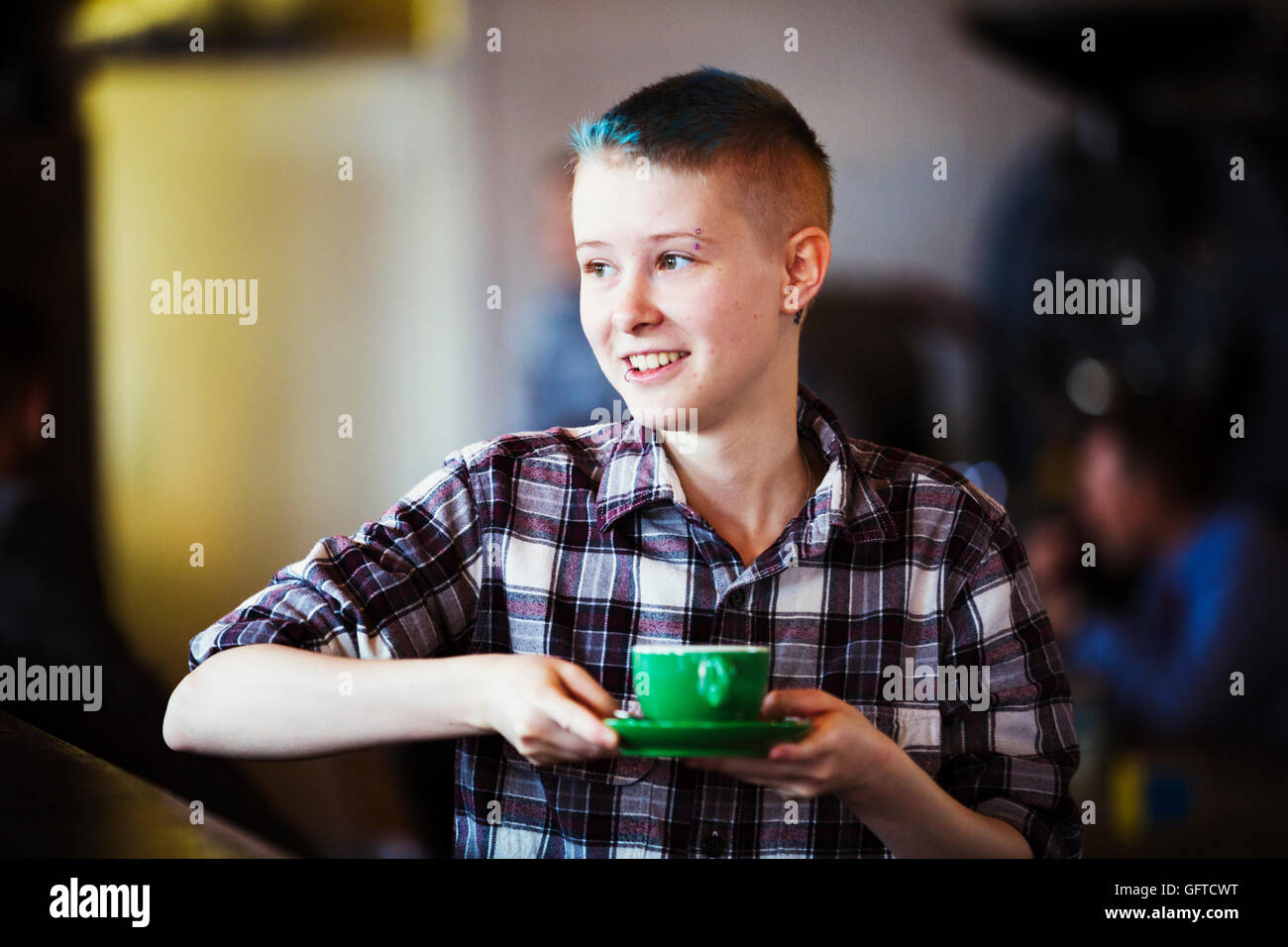 Ein junger Mensch mit einer Tasse Kaffee Stockfoto