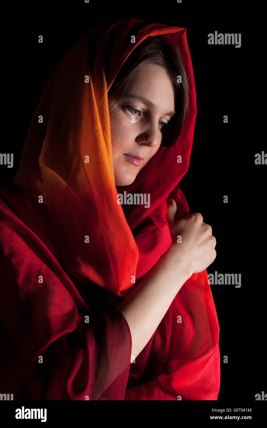 Frau im roten Kopftuch auf schwarzem Hintergrund isoliert Stockfoto
