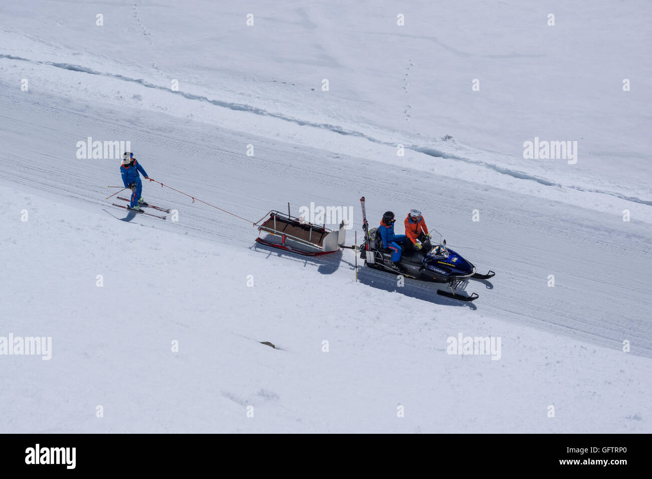 Skifahrer mit dem Schneemobil gezogen wird. Stockfoto