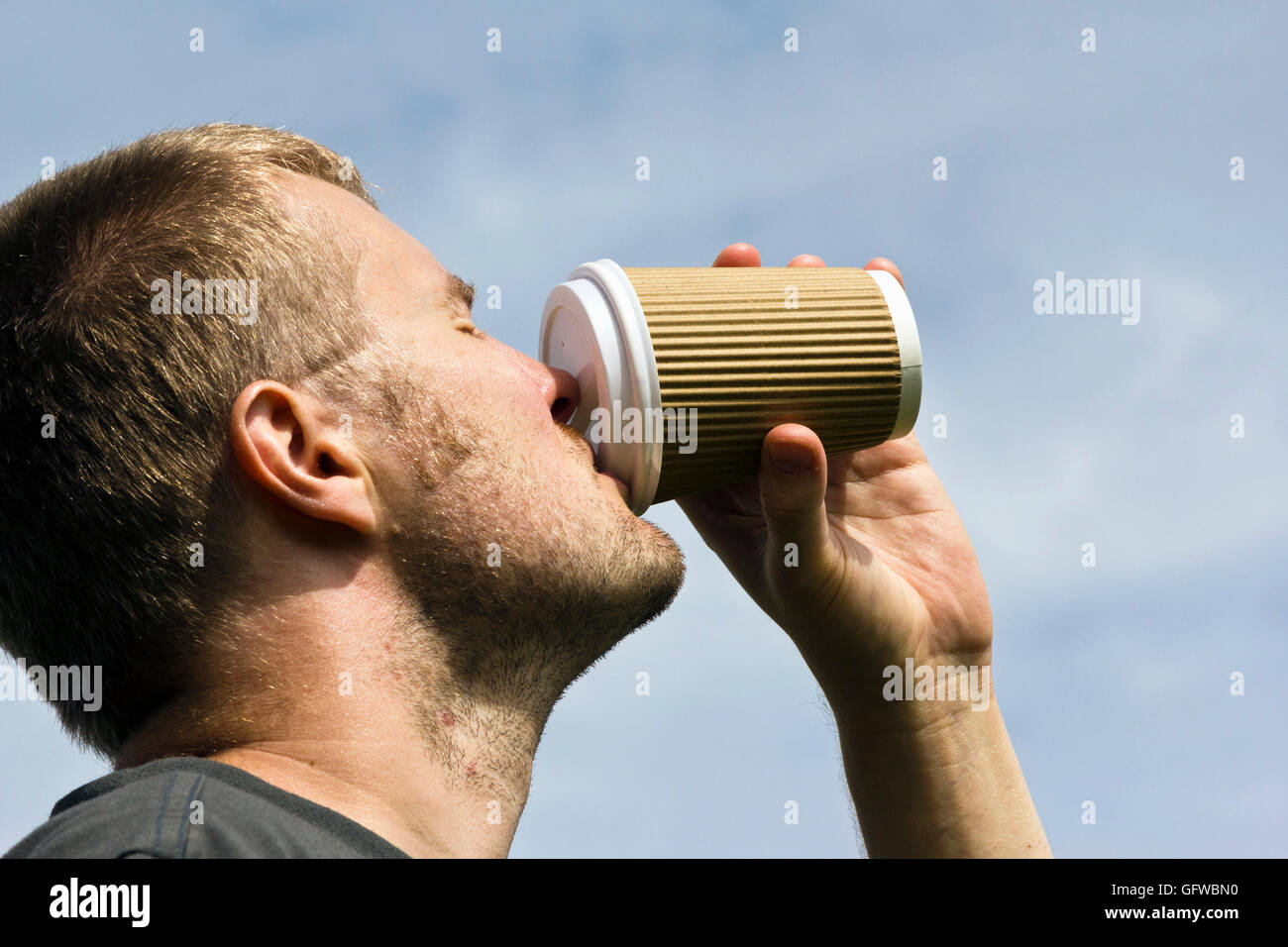Man trinkt einen Take away Kaffee aus einem Pappbecher Stockfoto