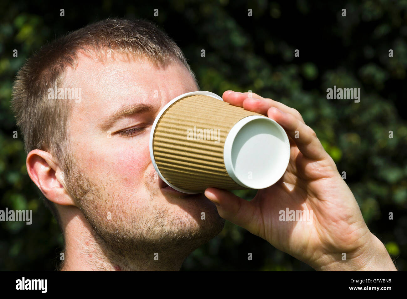 Man trinkt einen Take away Kaffee aus einem Pappbecher Stockfoto