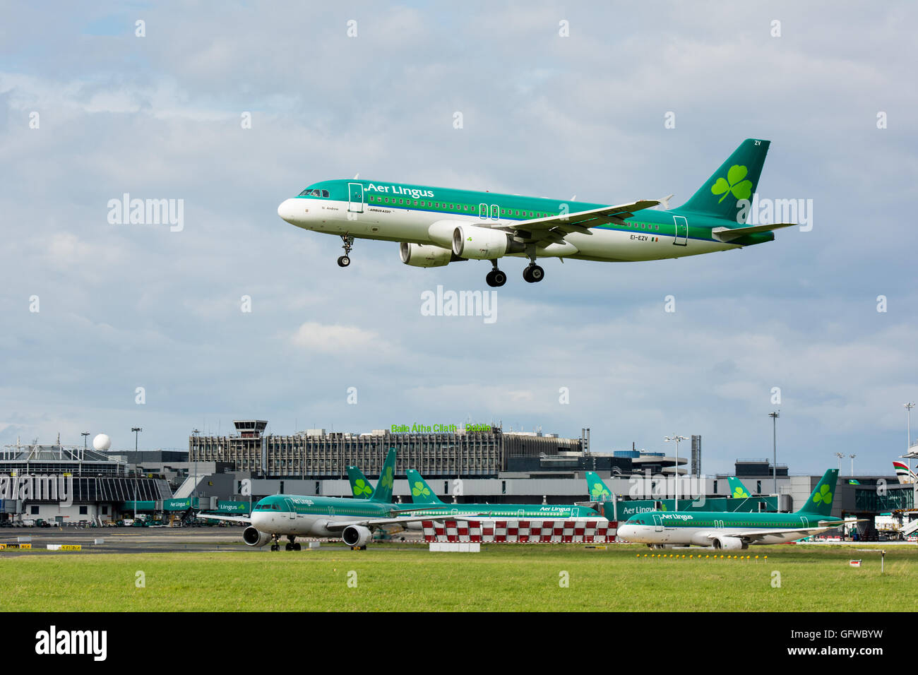 Aer Lingus Flugzeug landet auf dem Flughafen Dublin mit Aer Lingus Flugzeuge am Boden und Dublin Flughafen Zeichen auf dem terminal-Gebäude Stockfoto