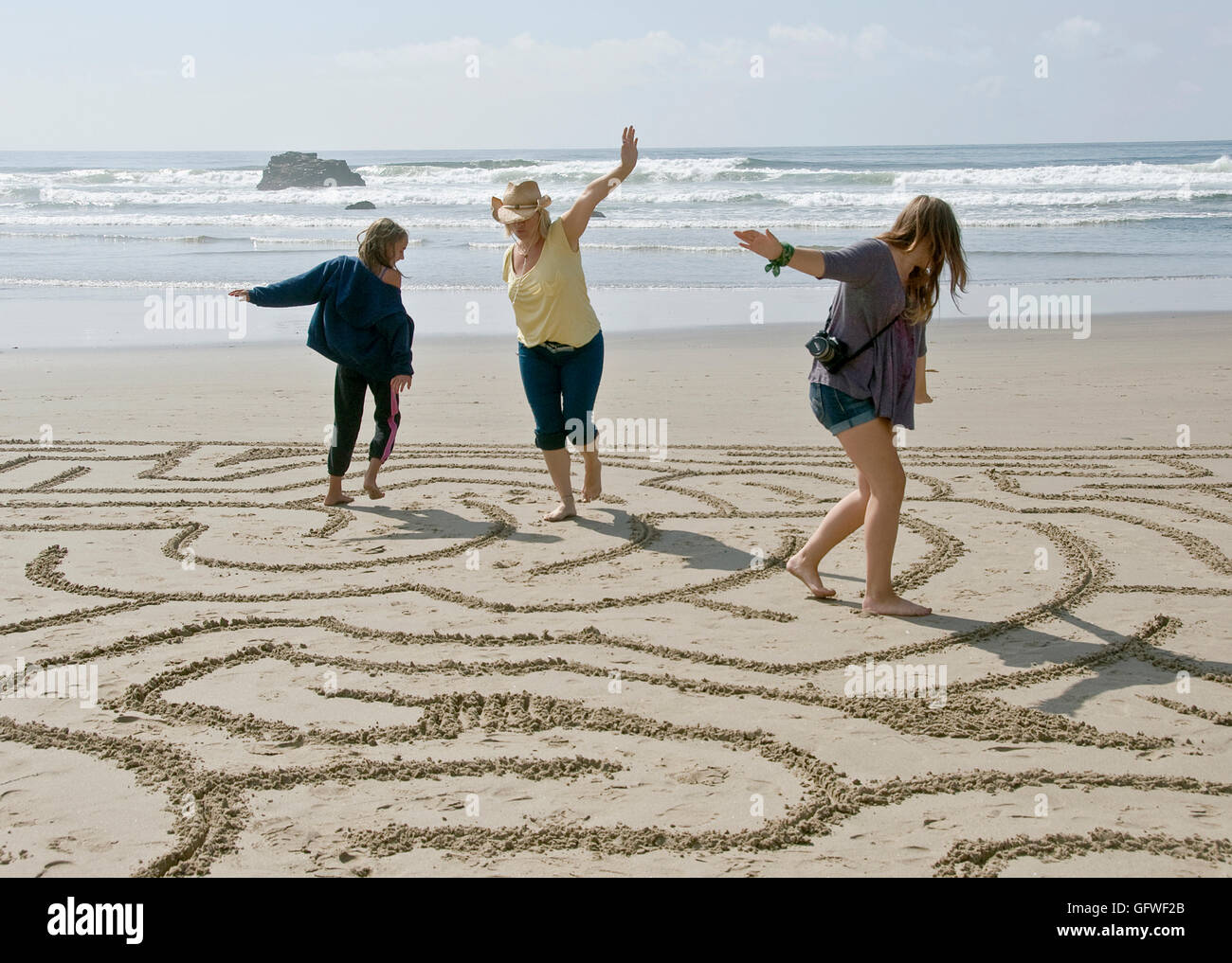 Eine Frau und zwei Mädchen gehen durch ein Labyrinth, Strand auf einem Oregon-Strand Stockfoto
