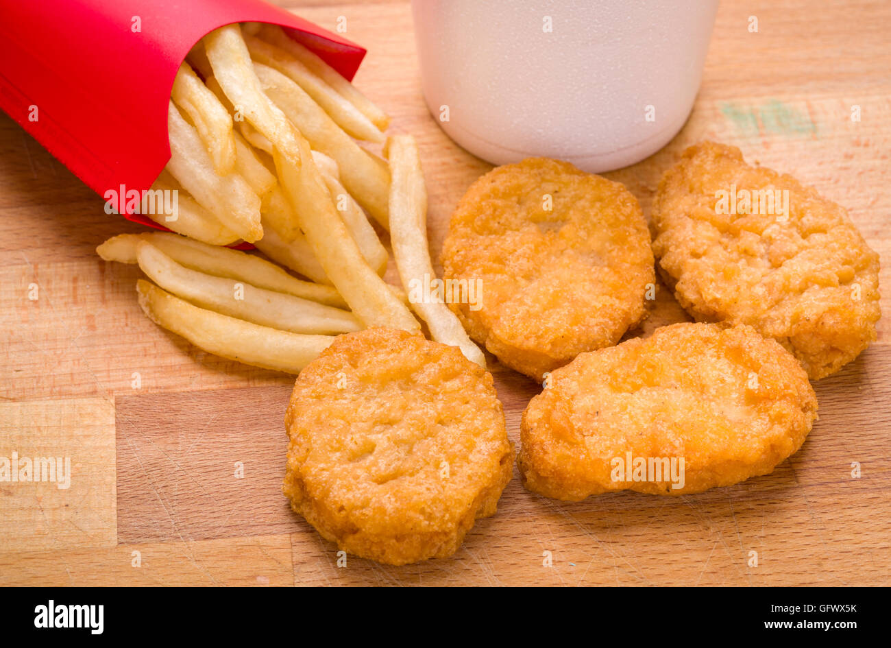 Kinder, Kind golden braun Chicken Nuggets und Pommes frites Essen auf Holz Hintergrund Stockfoto