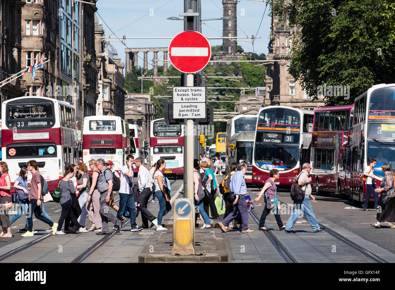 Blick auf Fußgänger überqueren die Straße und viele öffentliche Busse an der Princes Street in Edinburgh, Schottland, Vereinigtes Königreich Stockfoto