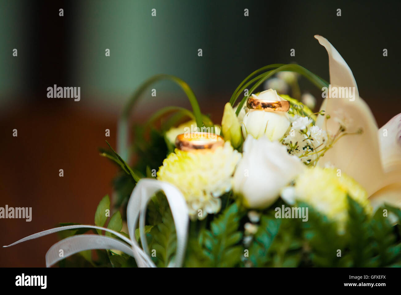 Nahaufnahme der Trauringe auf Hintergrund weiße Rosen. Stockfoto