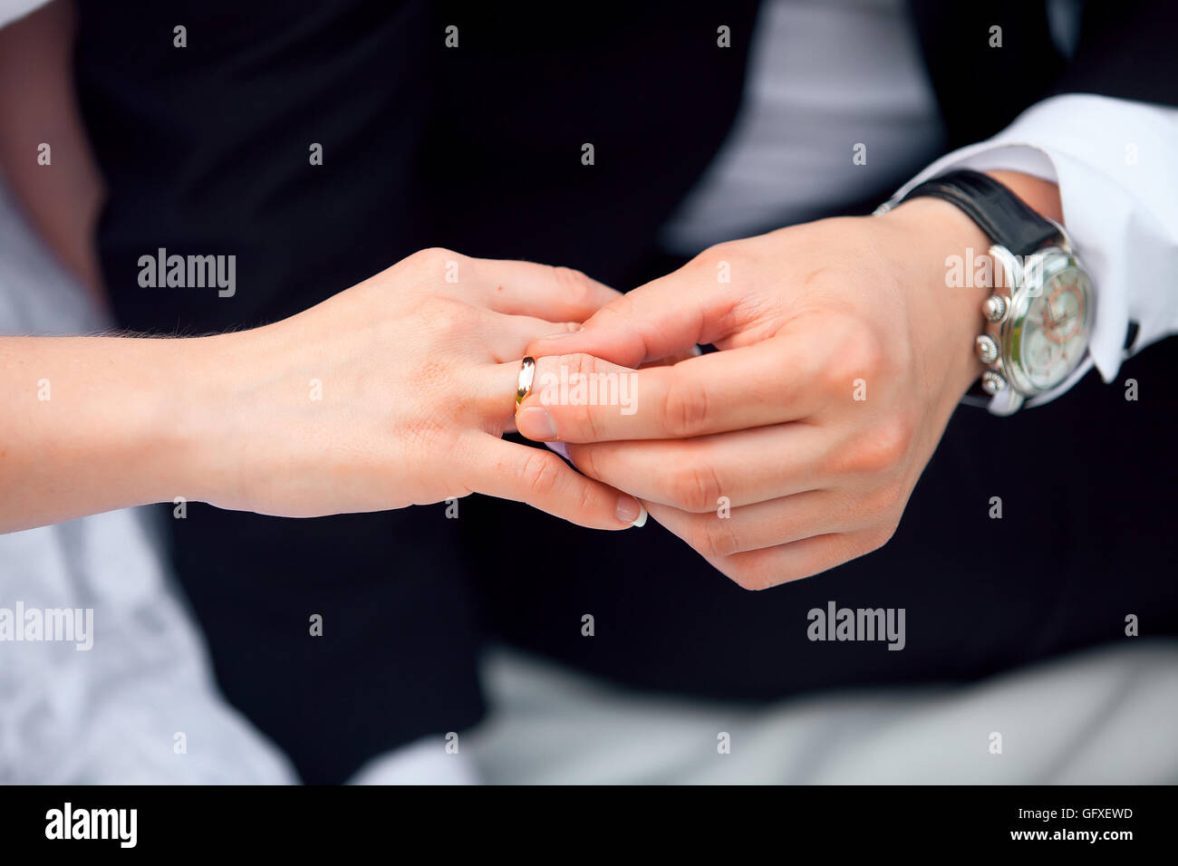 putting Ehering am Finger der Braut Bräutigam Stockfoto