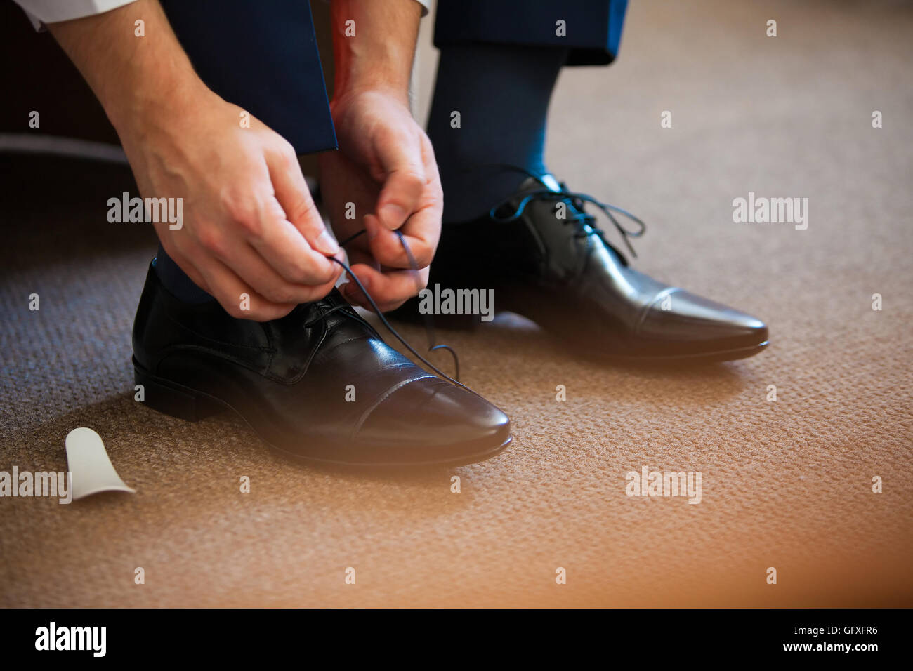 Mann fesselt seine shiney neue schwarze Leder Business Schuhe. Stockfoto