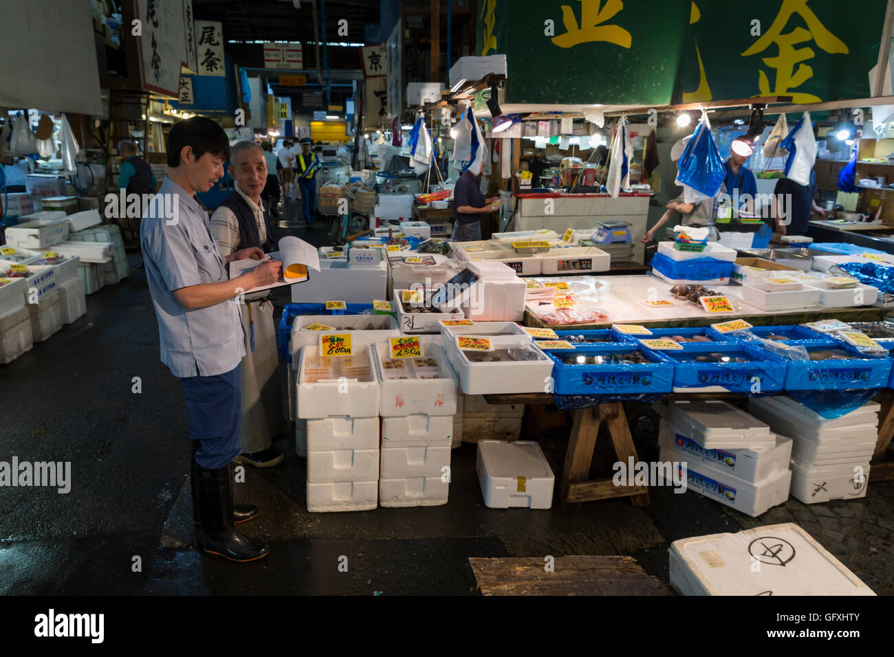 Ein Inspektor prüft, dass einer der Fische steht der Tsukiji-Fischmarkt in Tokio, Japan Stockfoto