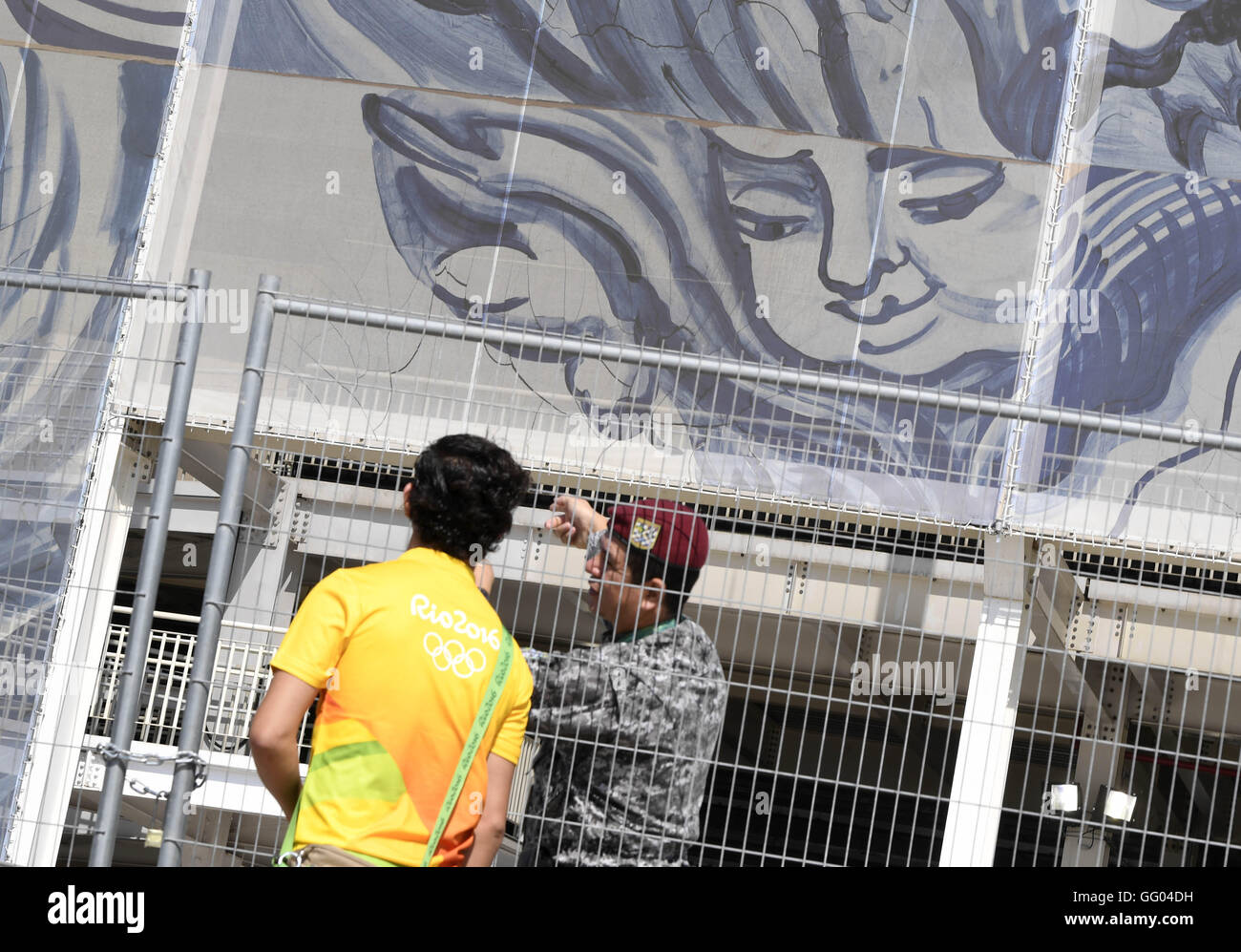 Rio De Janeiro, Brasilien. 2. August 2016. Ein freiwilliger spricht mit Sicherheit Mitglied neben dem Olympic Aquatics-Stadion in Rio De Janeiro, Brasilien, am 2. August 2016. Das Olympiastadion Aquatics ziert ein Kunstwerk des brasilianischen Künstlers Adriana Varejao. Die Fassaden bestehen von 66 Tafeln, je 27 Meter hoch, und sind durch Bilder von Meer und Engel mit einem gemischten Stil des portugiesischen Fliesen und barocke Kunst dekoriert. Das Material ist Anti-UV behandelt, um das Gebäude zu regulieren? s Temperatur. Bildnachweis: Wu Wei/Xinhua/Alamy Live-Nachrichten Stockfoto