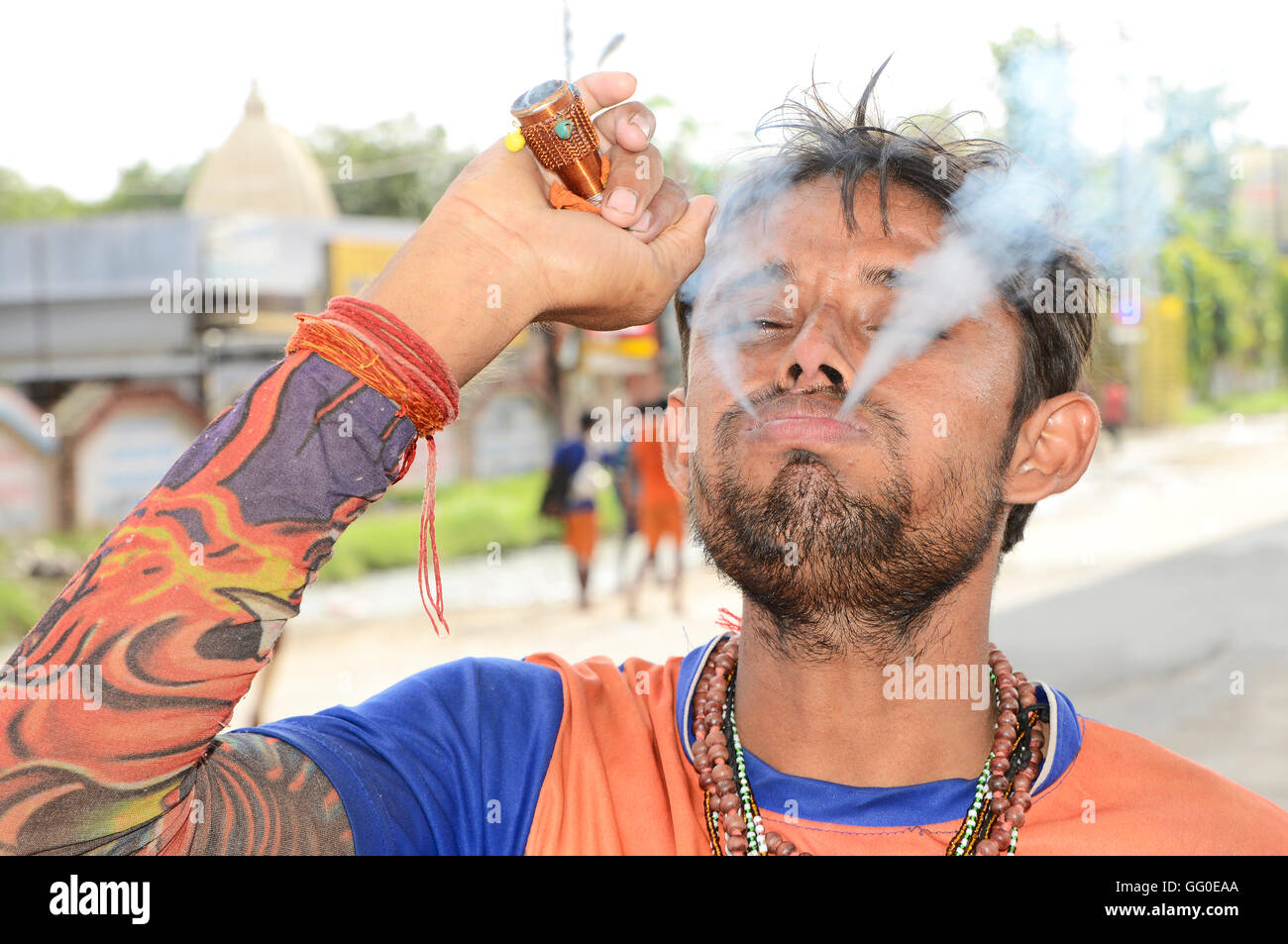 Indischer Mann raucht eine Pfeife Ton Stockfoto