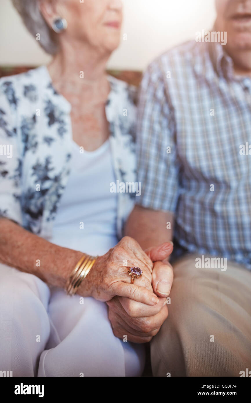 Schuss von älteres paar Hand in Hand zusammen sitzen abgeschnitten. Konzentrieren Sie sich auf Händen. Stockfoto