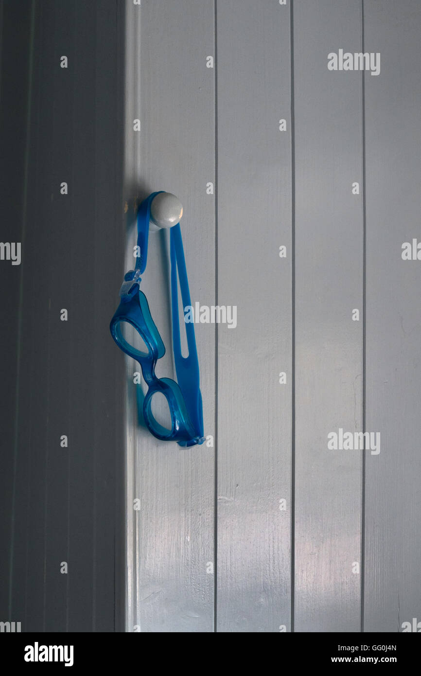 Blaue Schwimmbrille hängen an der Tür Knopf Nut und Schrank in einem Badezimmer, UK Stockfoto