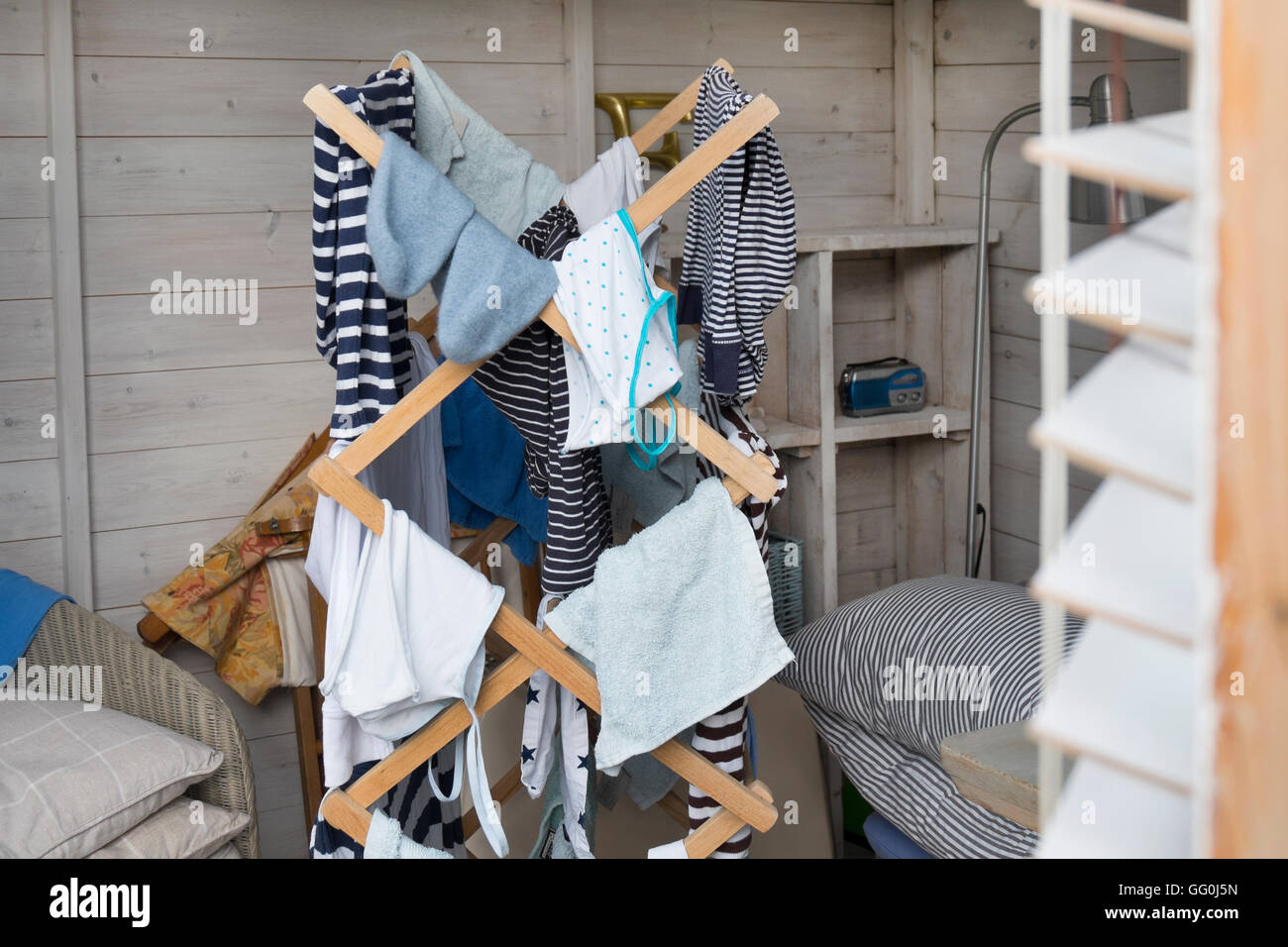 Blaue und weiße Streifen Wäscheständer auf einem altmodischen hölzernen Airer in einem Sommerhaus, UK. Stockfoto