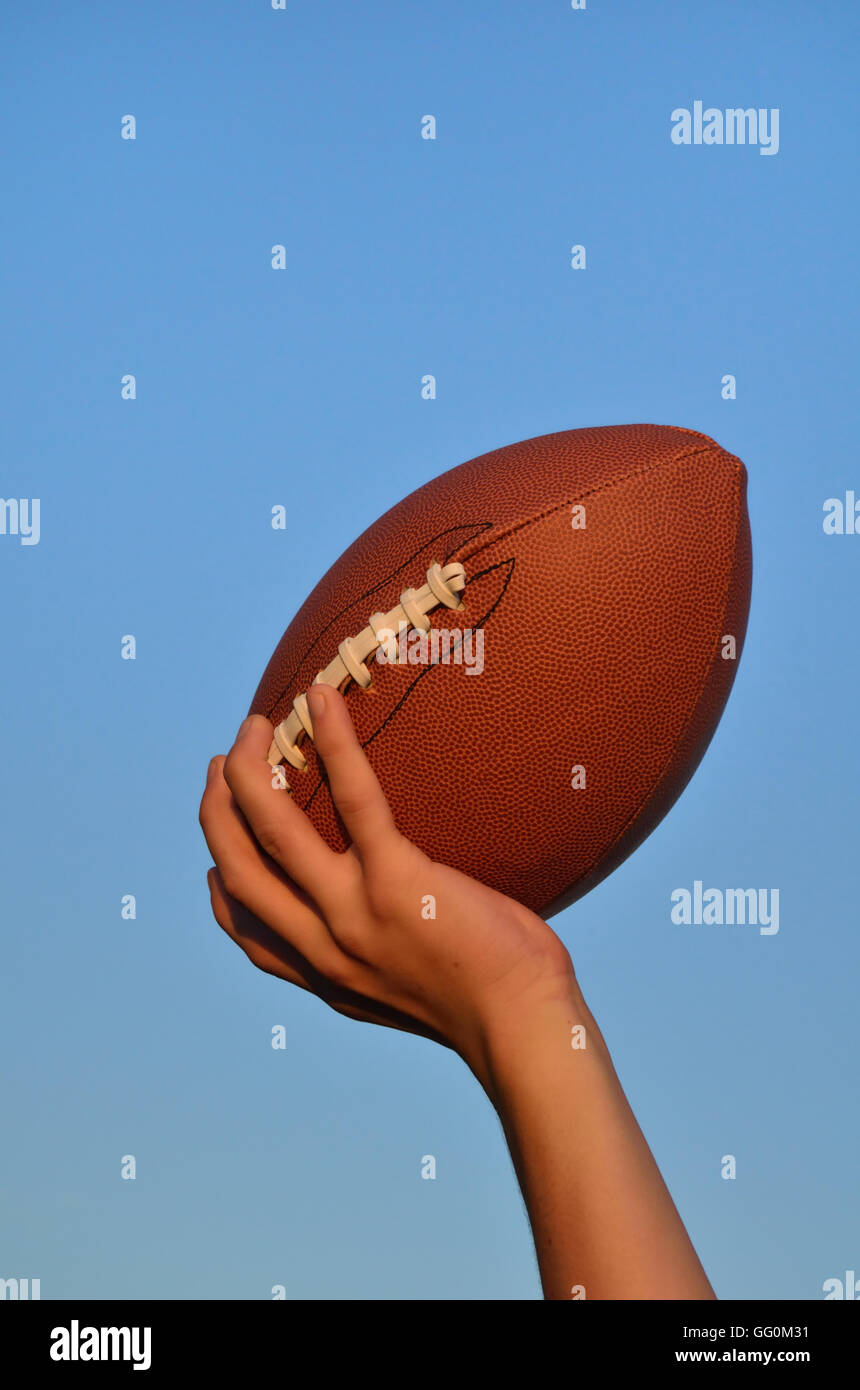 Quarterback wirft ein American Football vor blauem Himmel Stockfoto
