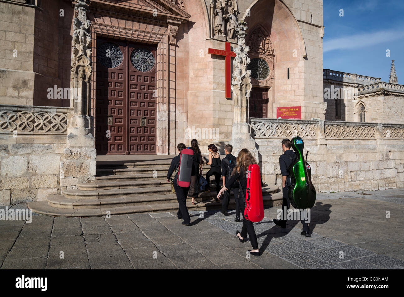 Junge Musiker mit ihren Instrumenten auf dem Rücken zu Fuß in Richtung der Kathedrale, Burgos, Kastilien und Leon, Spanien Stockfoto