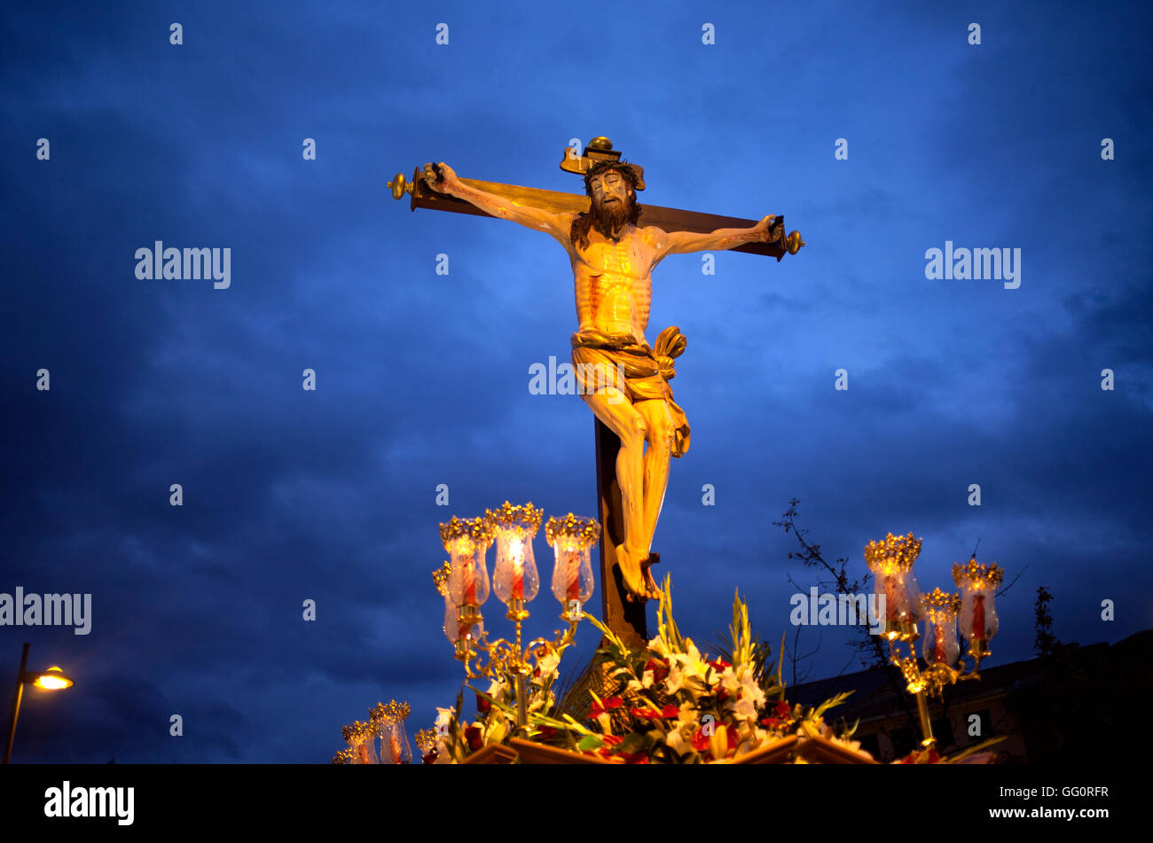 Ein Bild des gekreuzigten Jesus Christus erscheint bei Sonnenuntergang während einer Prozession der Karwoche in Astorga, Leon, Spanien Stockfoto