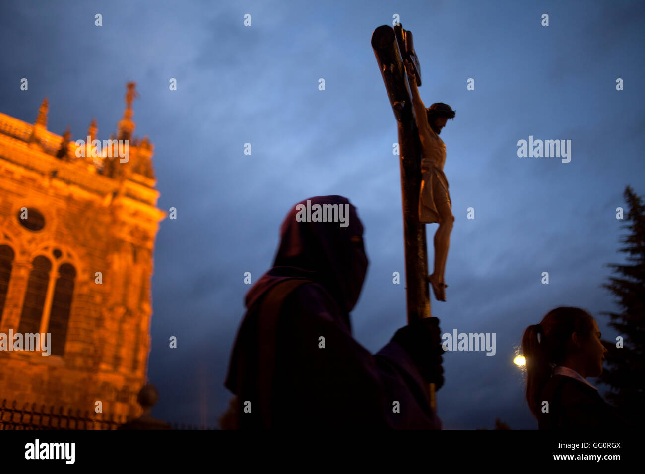 Ein vermummte Mann hält ein Kruzifix während einer Prozession der Karwoche in Astorga, Castilla y Leon, Spanien. Stockfoto