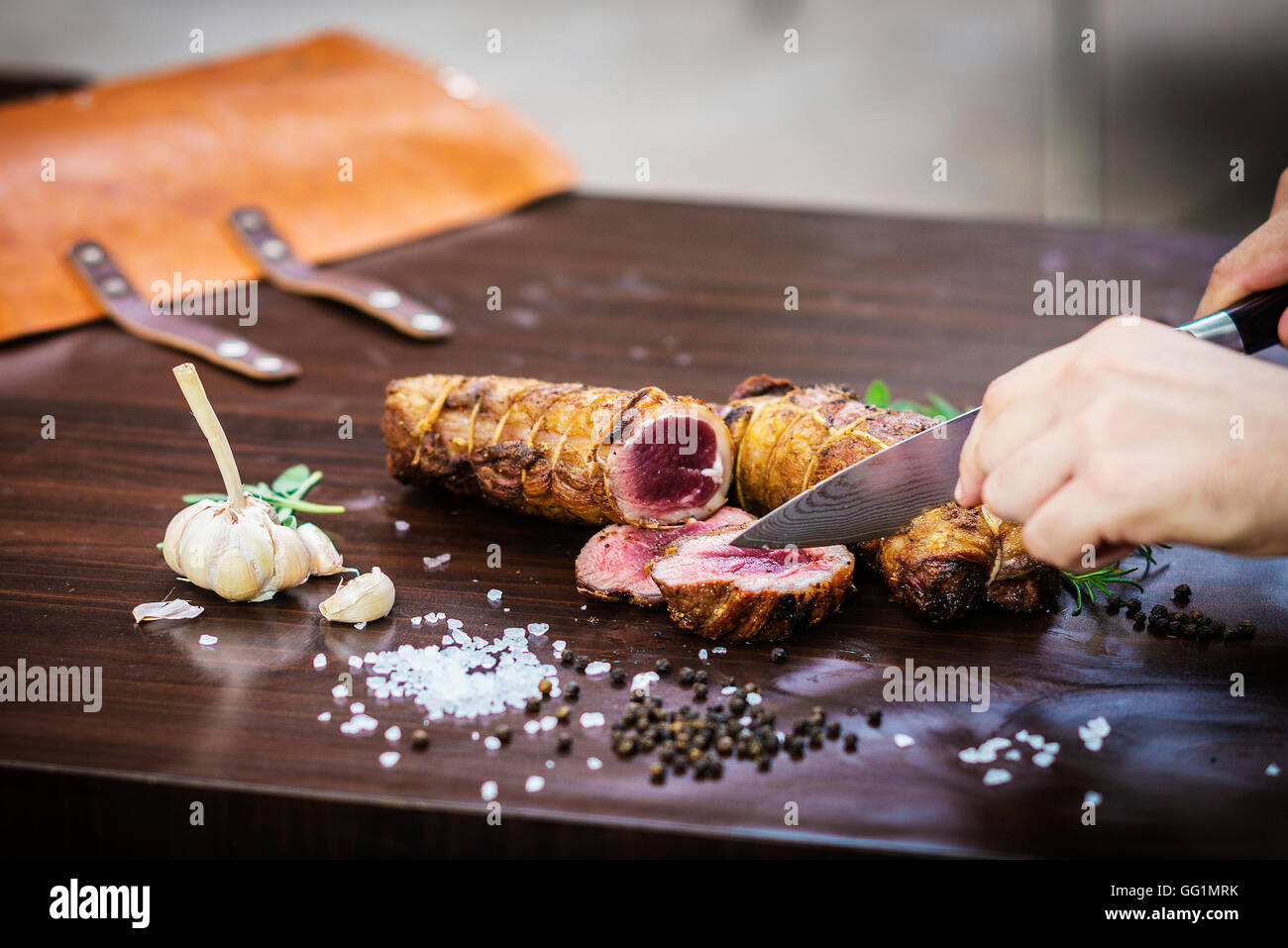 Portion Carving gebratenes Schweinefleisch roll Mahlzeit im rustikalen Stil mit Gewürzen Stockfoto